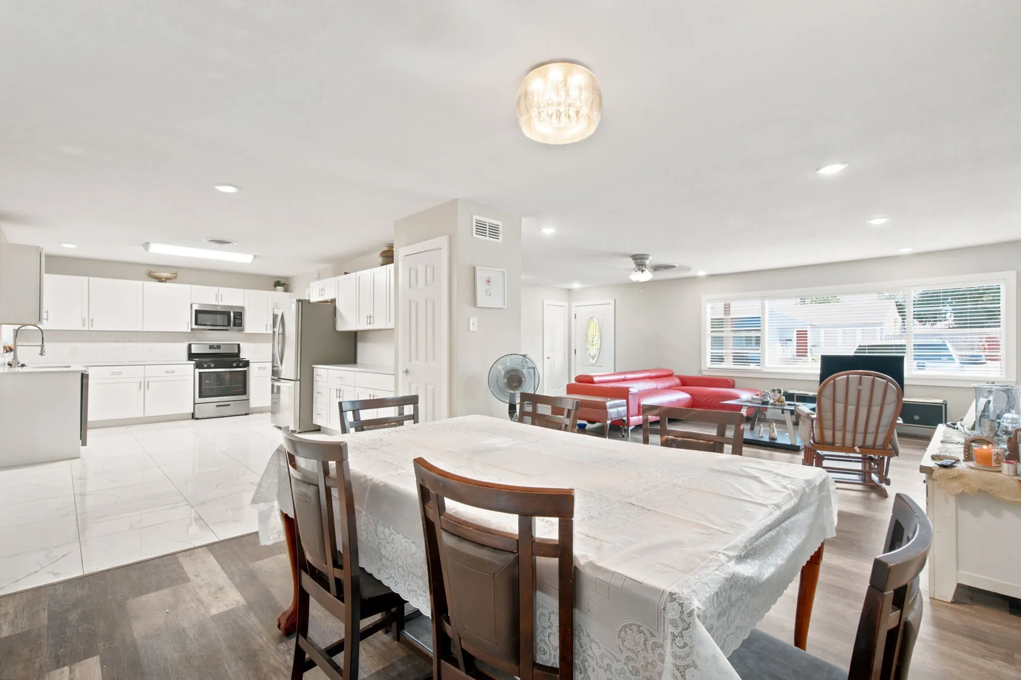 Open-concept living area featuring wood-finish flooring, recessed lighting, and a chandelier