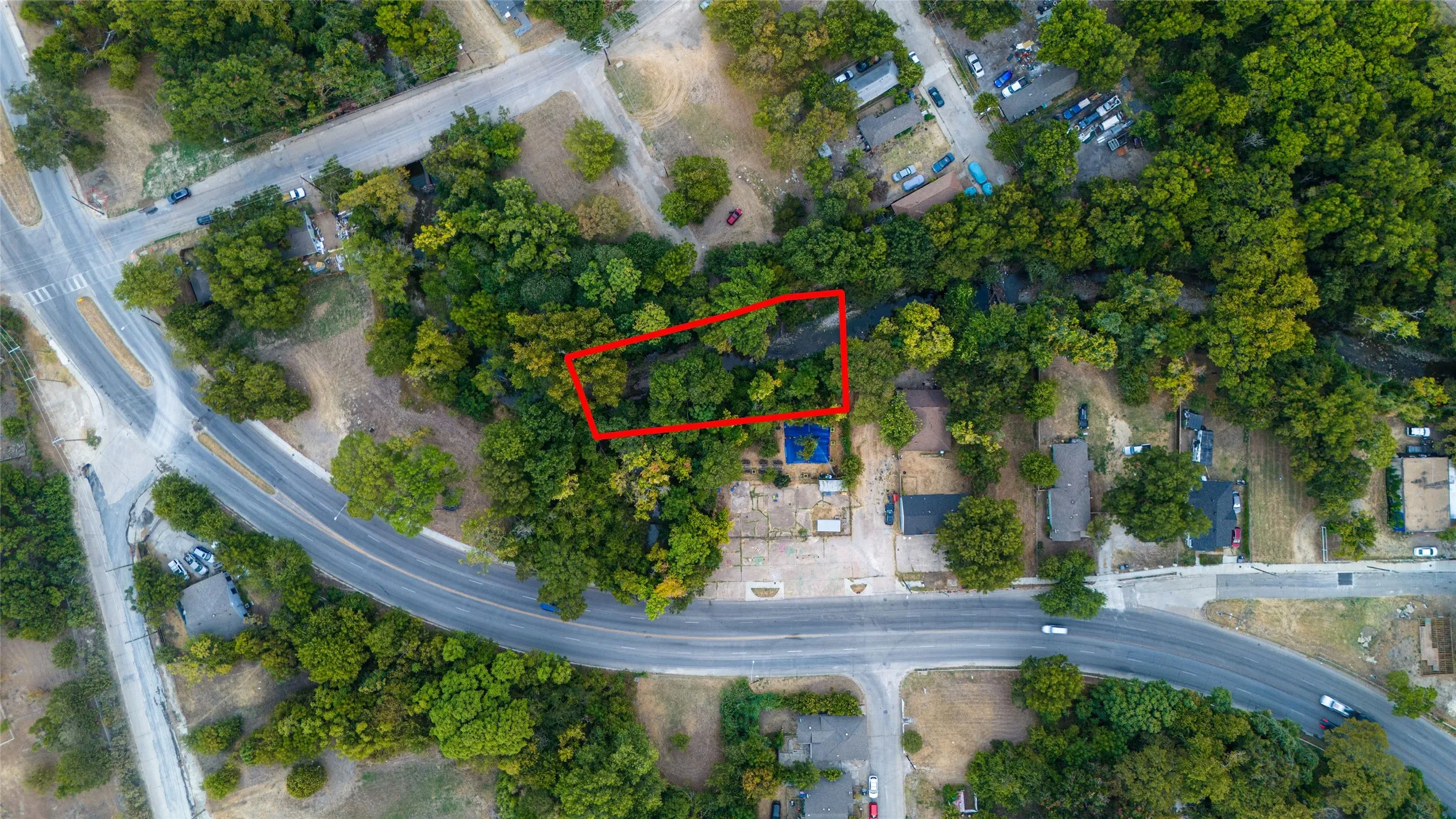 Aerial perspective of a verdant lot surrounded by established trees