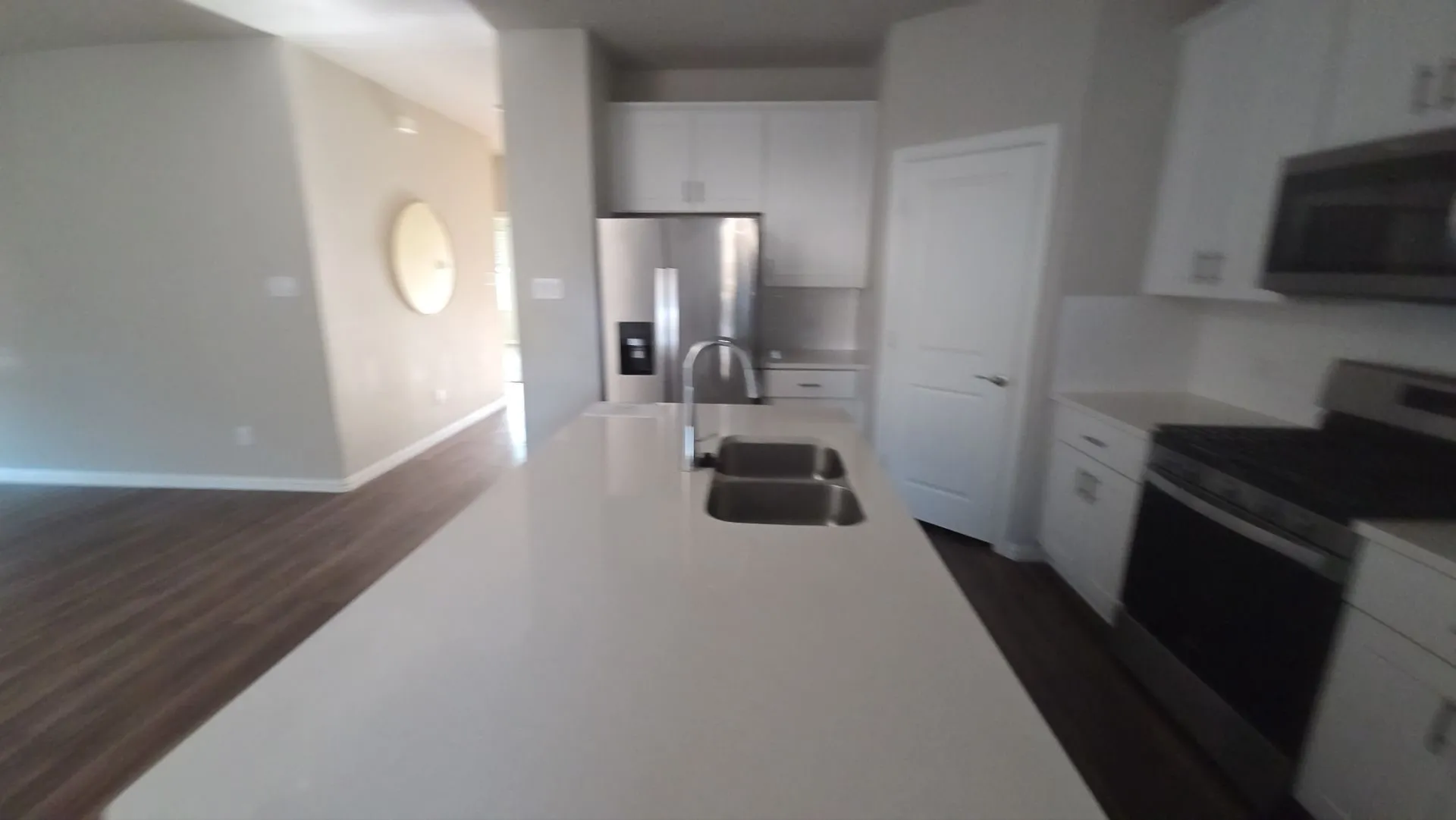 Kitchen island with undermount double-basin sink and gooseneck faucet