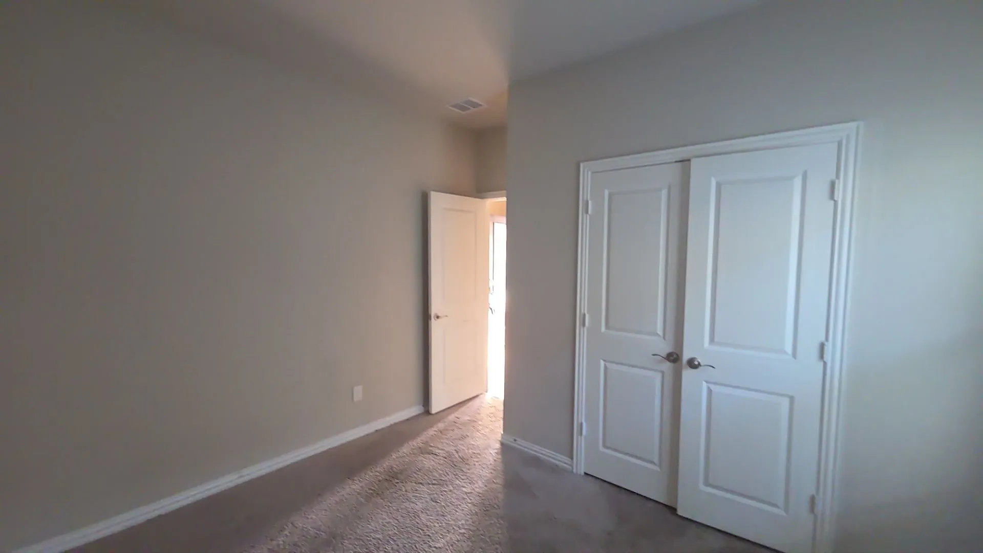 Neutral-toned walls, plush carpet flooring, white trim, and a white paneled bi-fold door