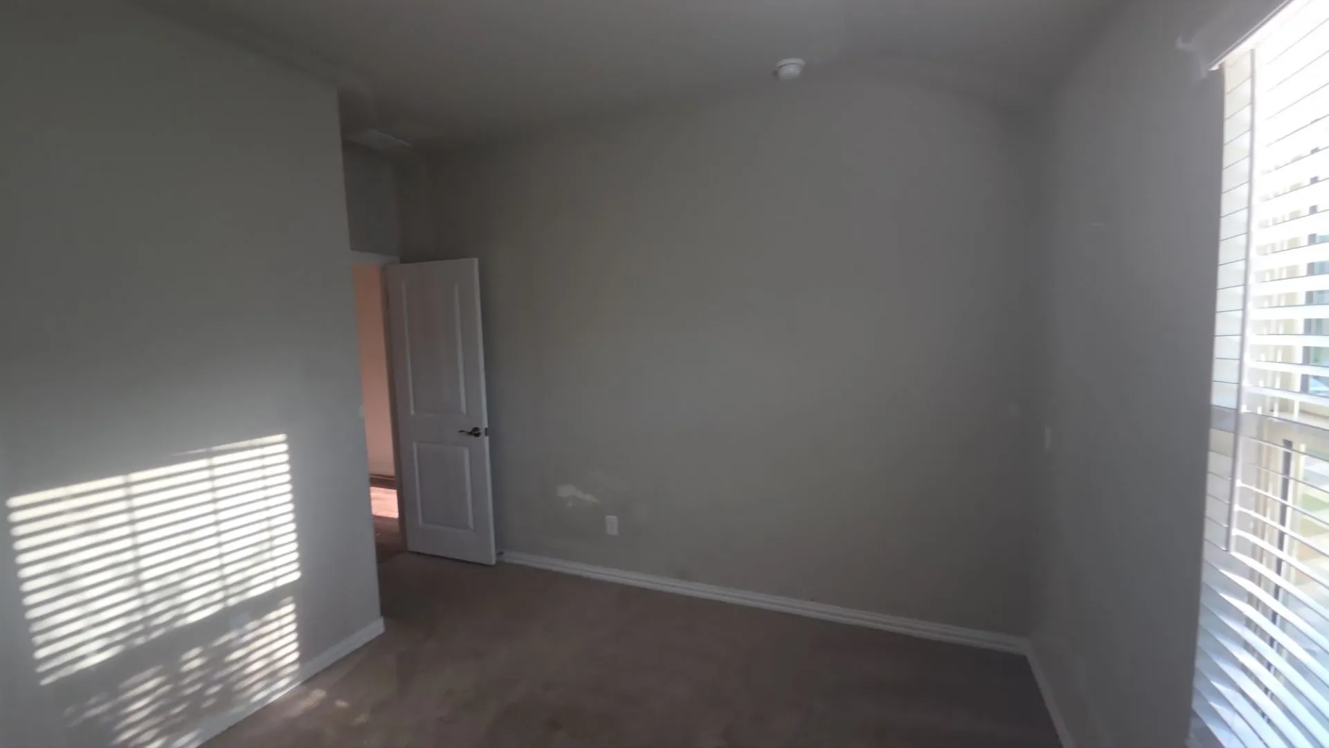 Carpeted flooring, vaulted ceiling, white interior door, and blinds on windows