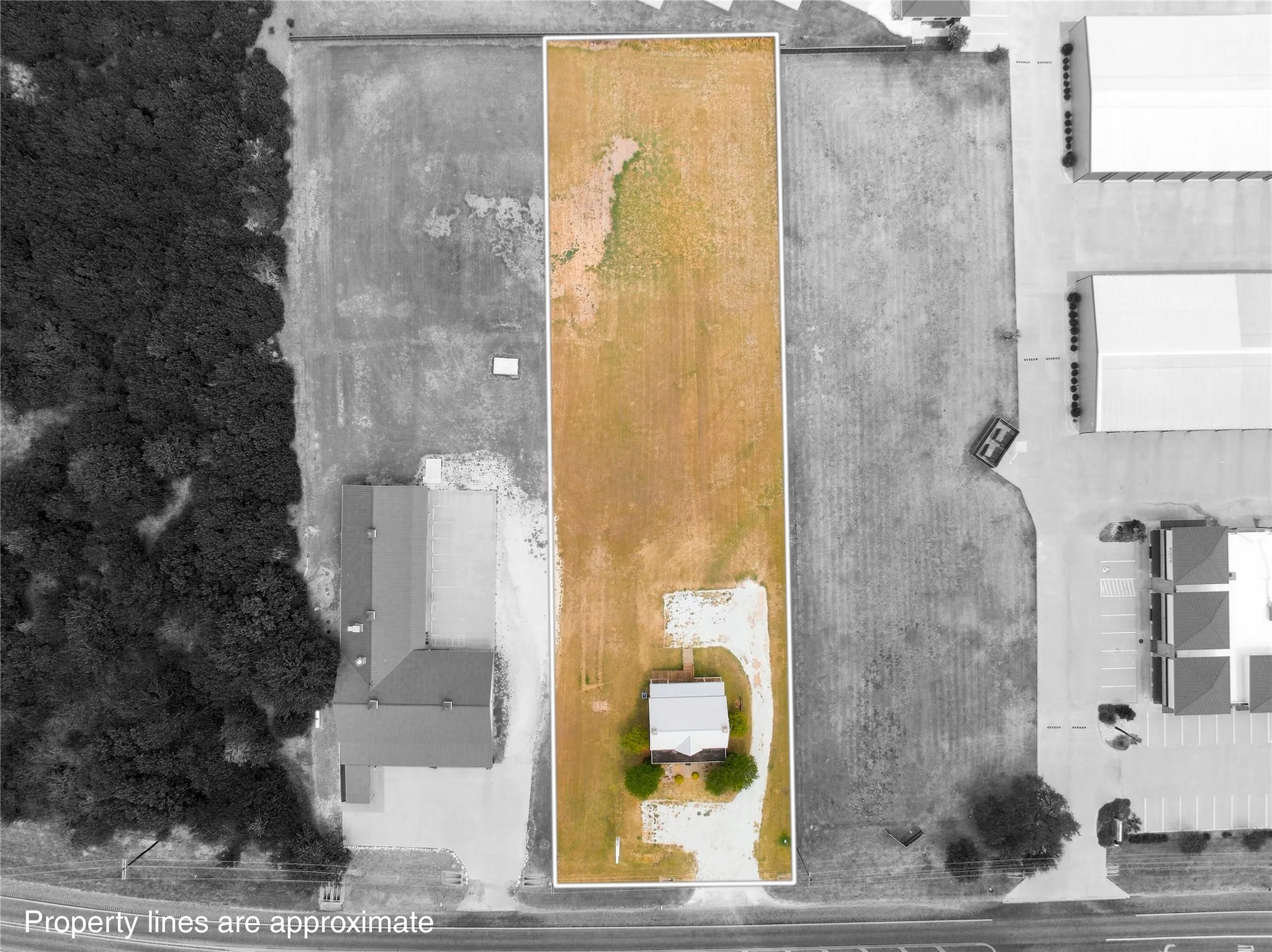 Elongated rectangular lot with a single structure and a gravel driveway