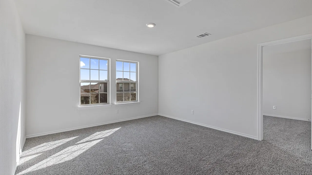 Neutral wall colors, recessed ceiling lighting, light gray carpeting, and multiple windows