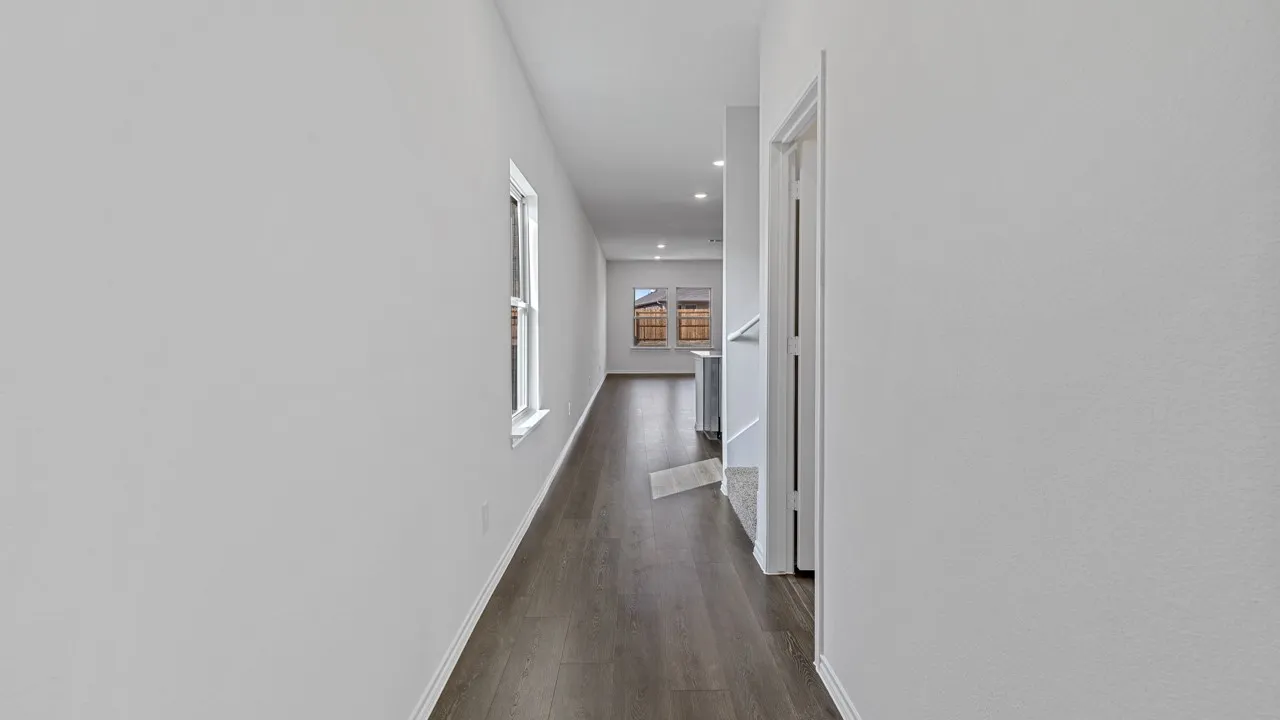 Hallway featuring wood-finish flooring, white walls, and recessed lighting