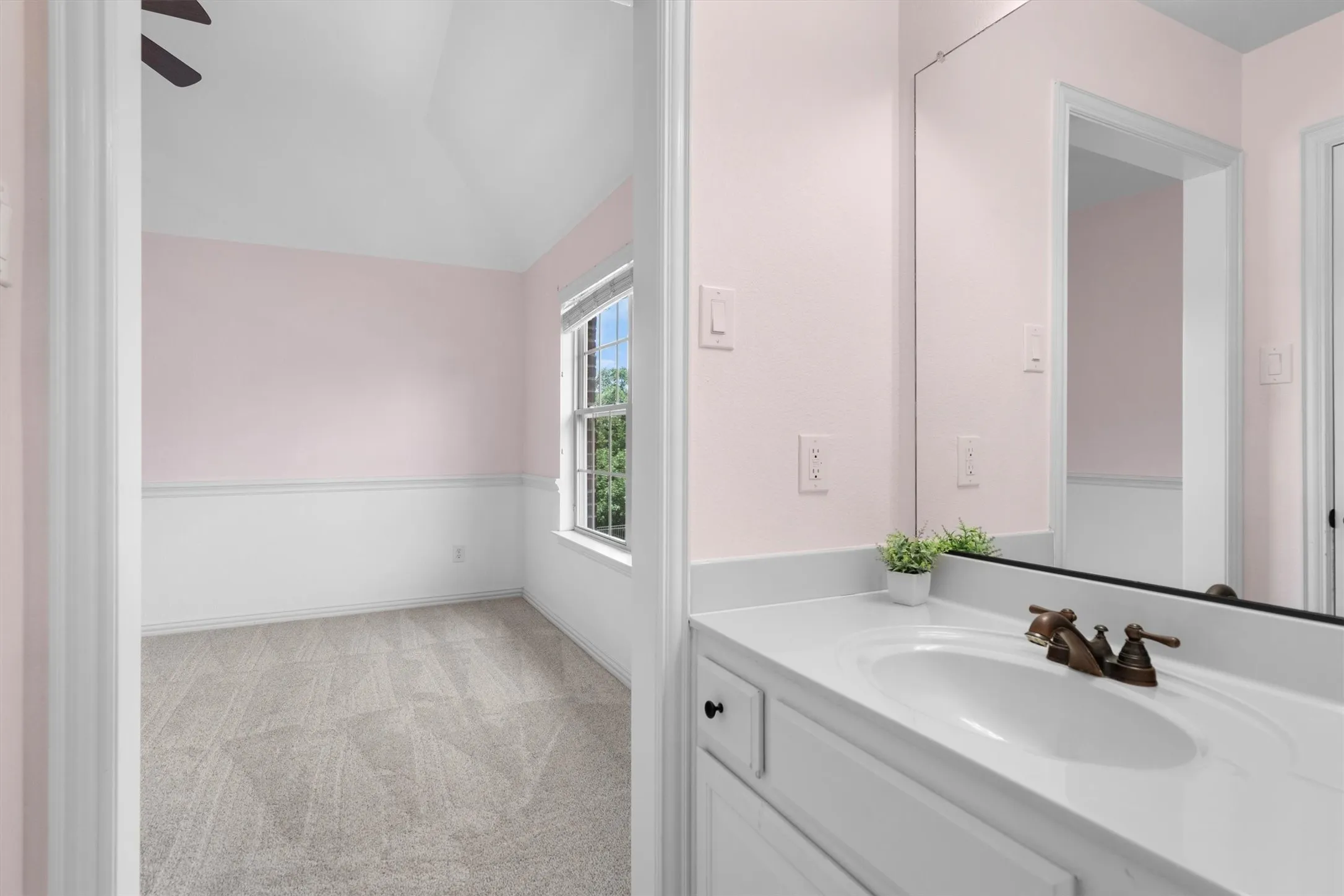Attached bathroom with vanity and mirror