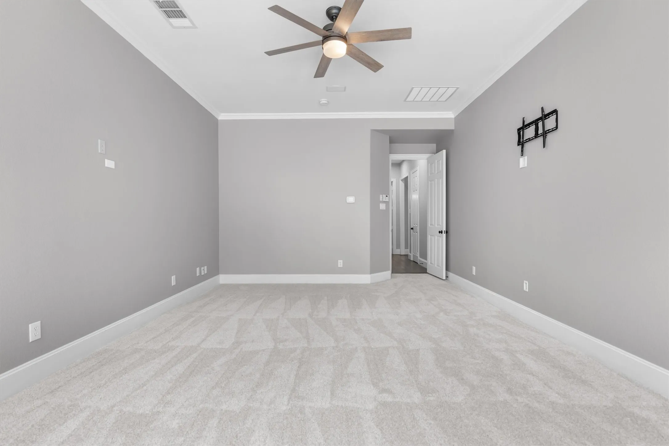 Spacious primary bedroom with ceiling fan and flexible sitting area