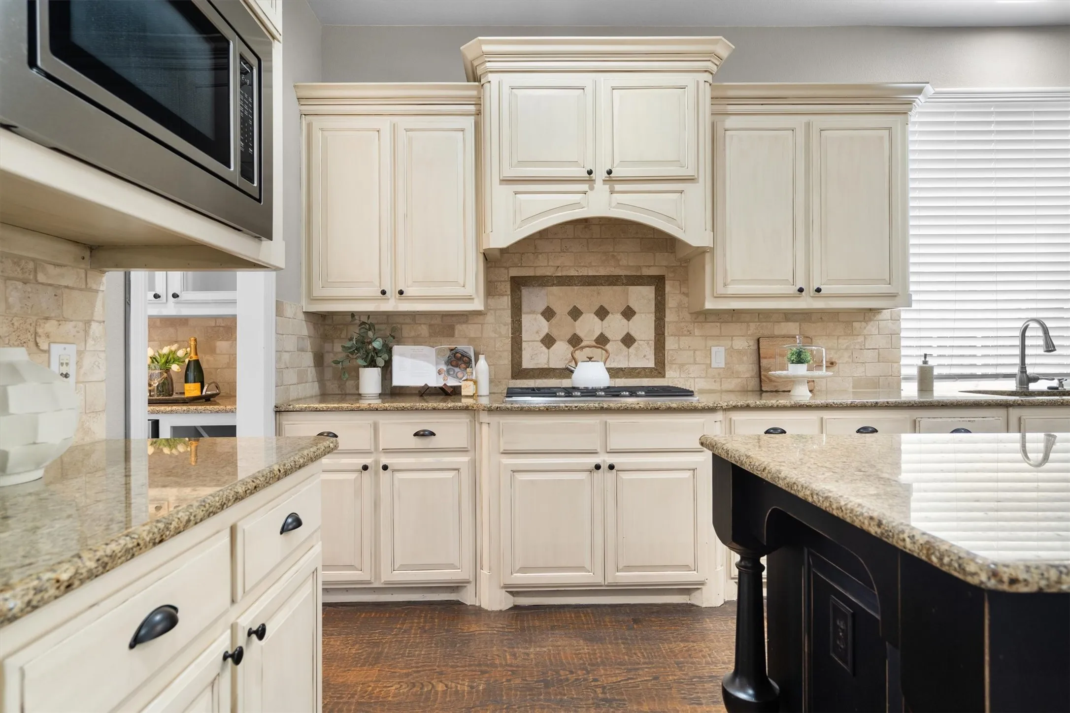 Kitchen view highlighting tile backsplash, built-in microwave & ample cabinetry