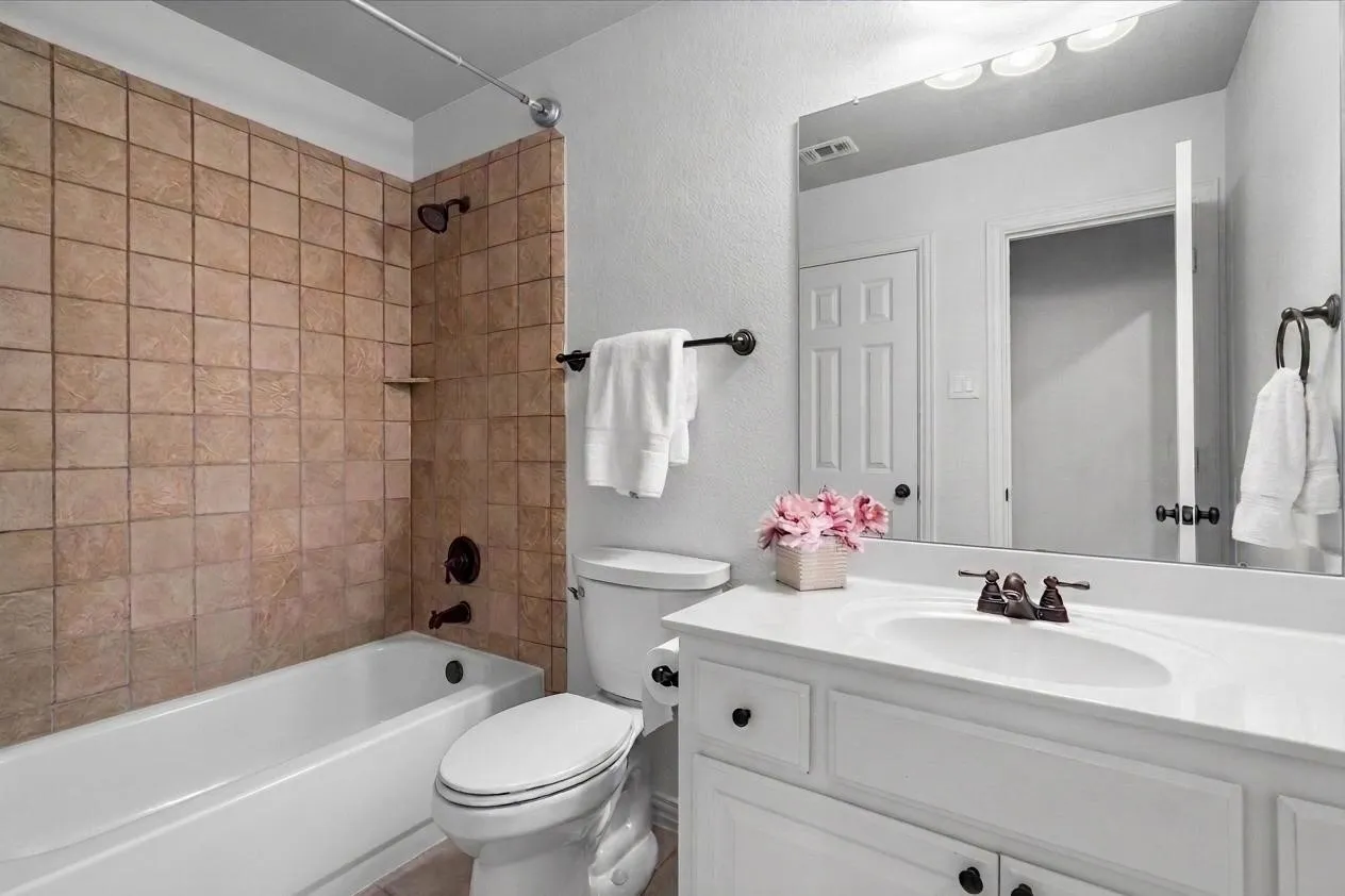Attached bathroom with tub/shower combo and tile surround
