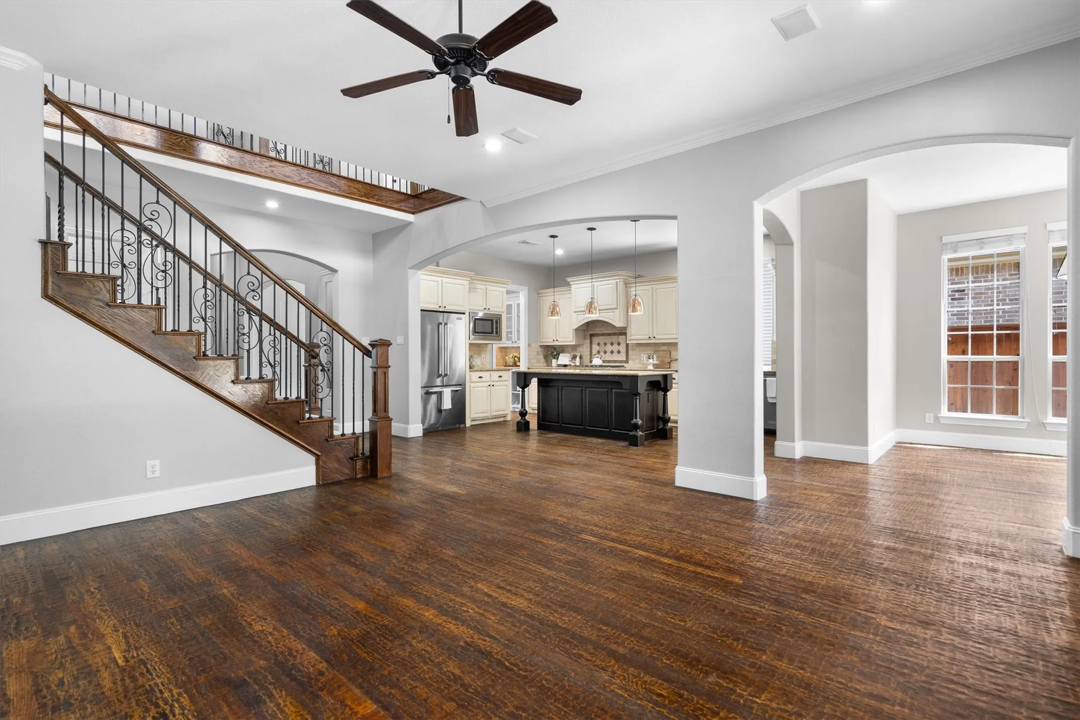 Open-concept view connecting living room, staircase & gourmet kitchen