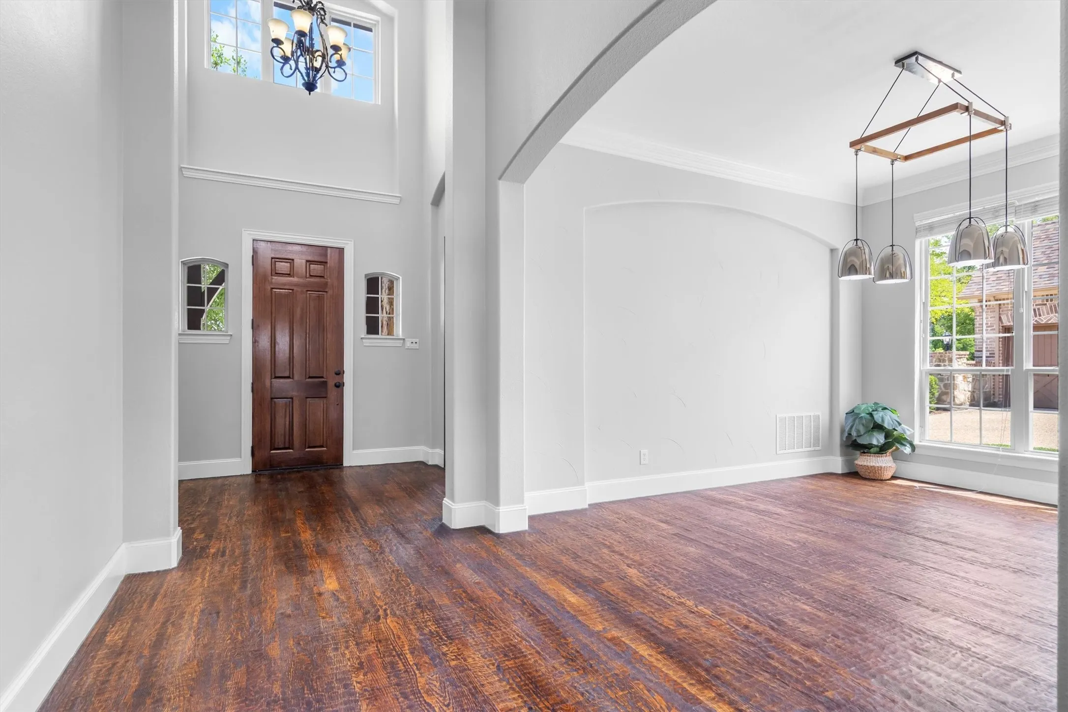 Bright entryway with soaring ceilings, rich hardwood floors & elegant chandelier