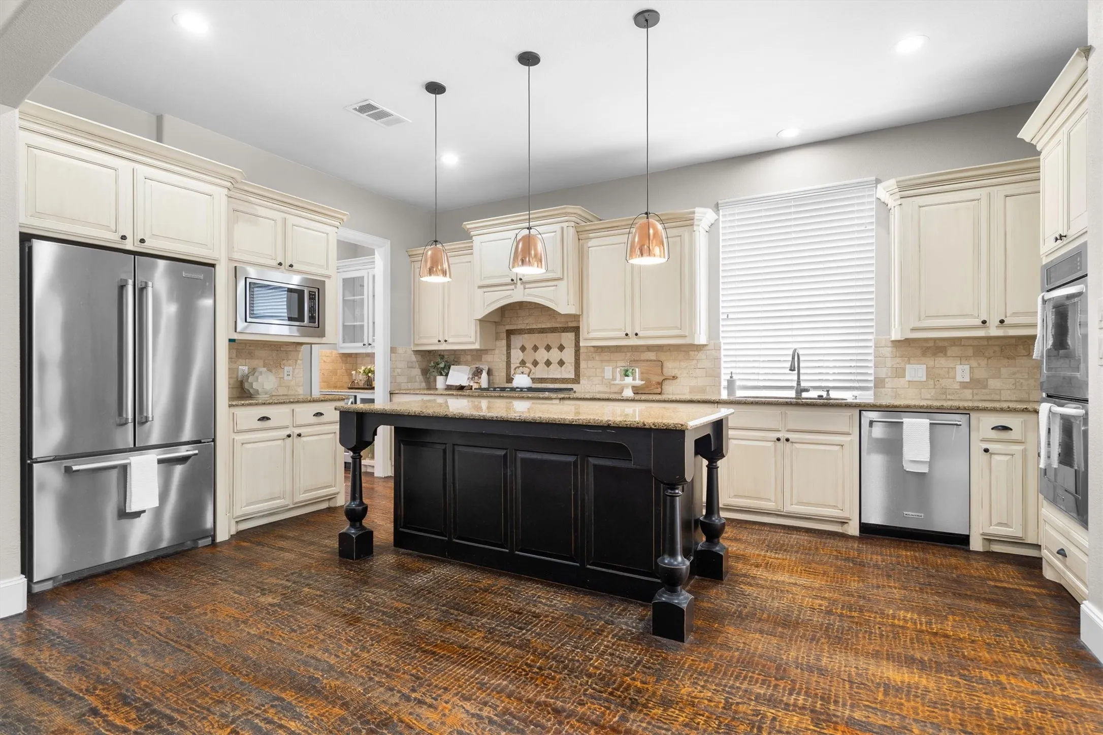 Gourmet island kitchen with cream cabinetry, granite counters & stainless appliances