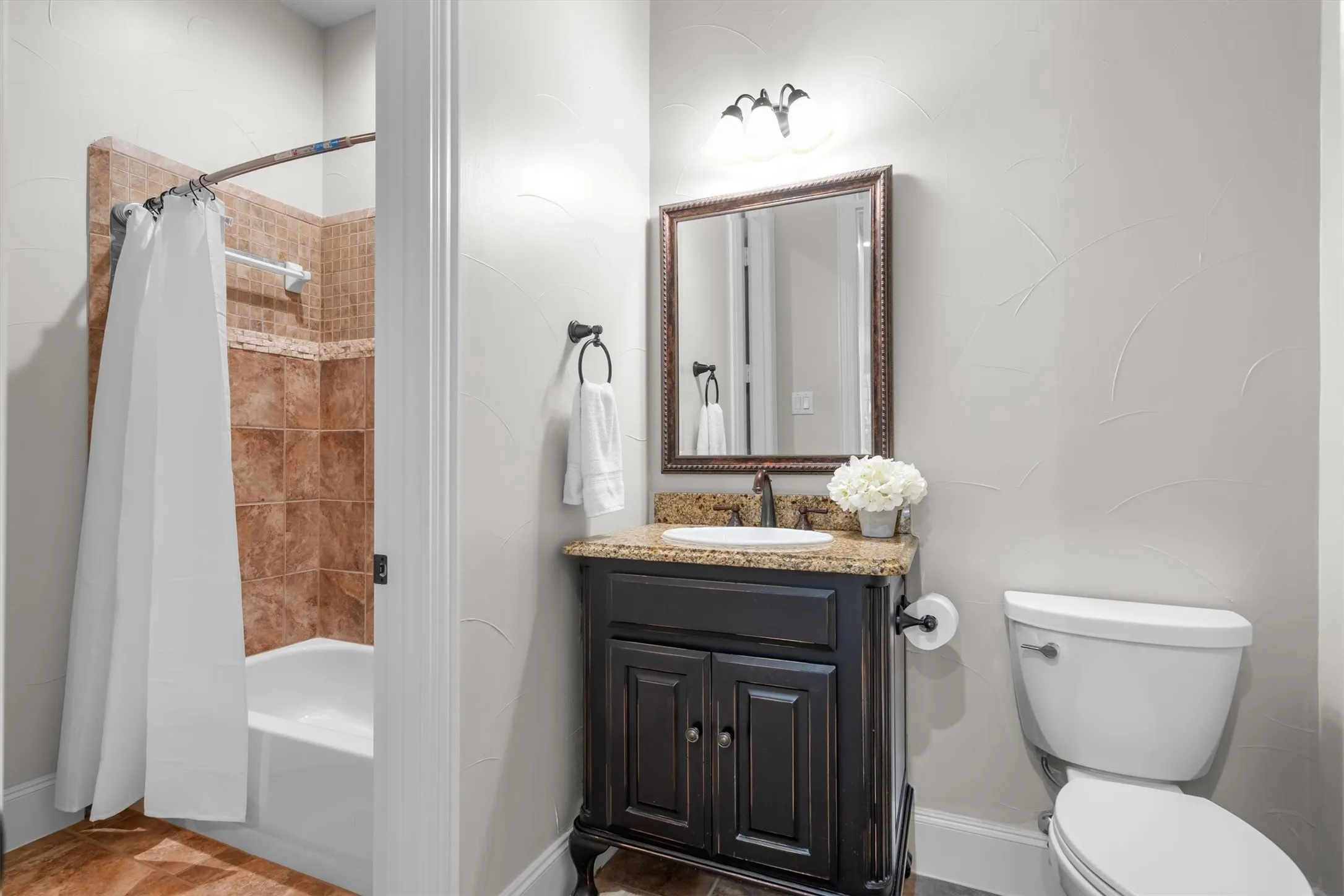 Full bathroom with shower/tub combo, tile surround and updated vanity