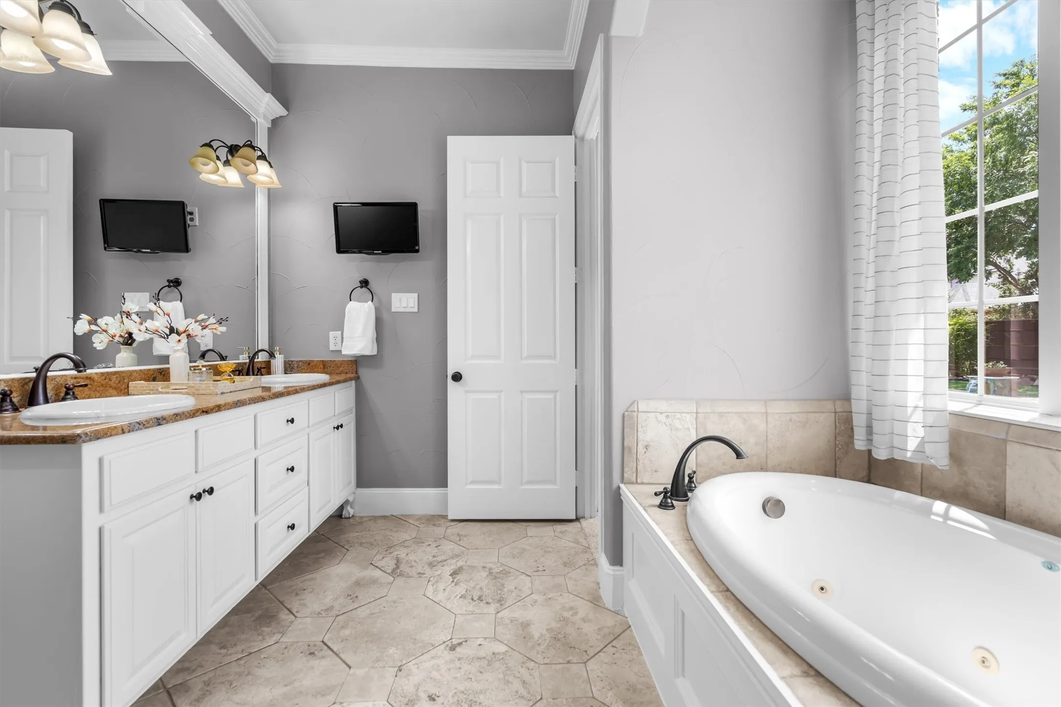 Primary bath featuring garden soaking tub and abundant natural light