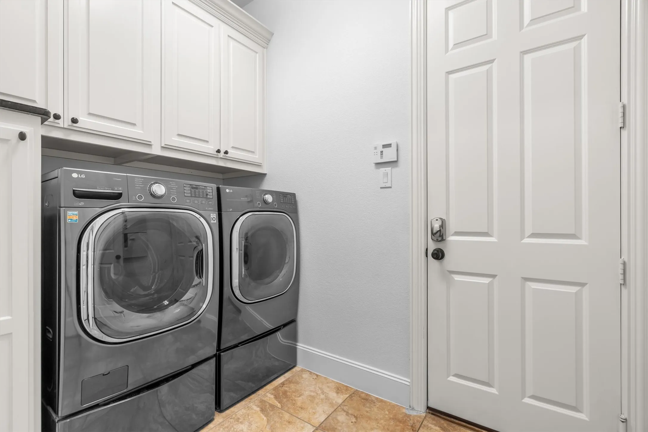 Laundry room with built-in cabinetry and included washer/dryer