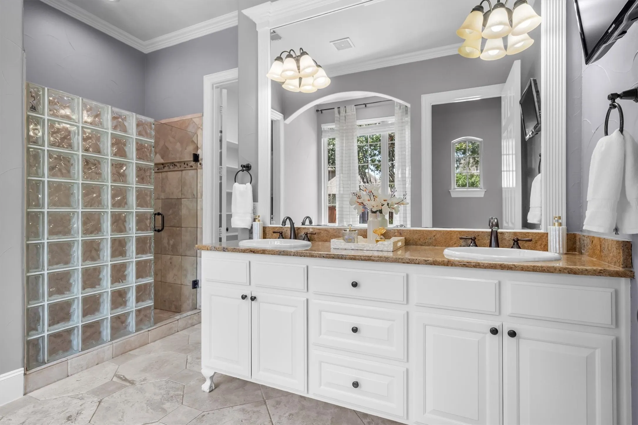 Spa-inspired primary bath with dual vanities and glass-block walk-in shower
