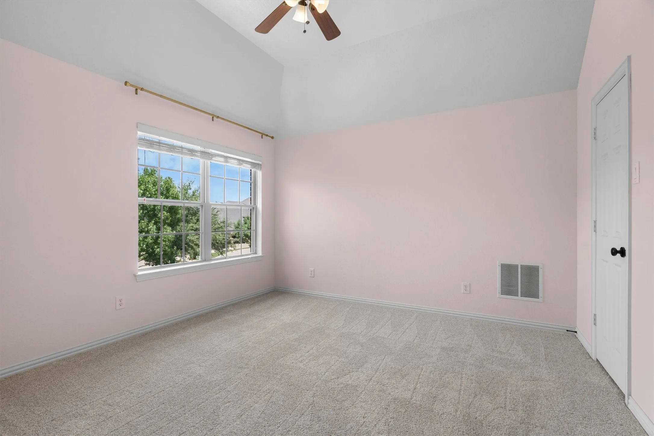 Upstairs bedroom with neutral carpet and large window
