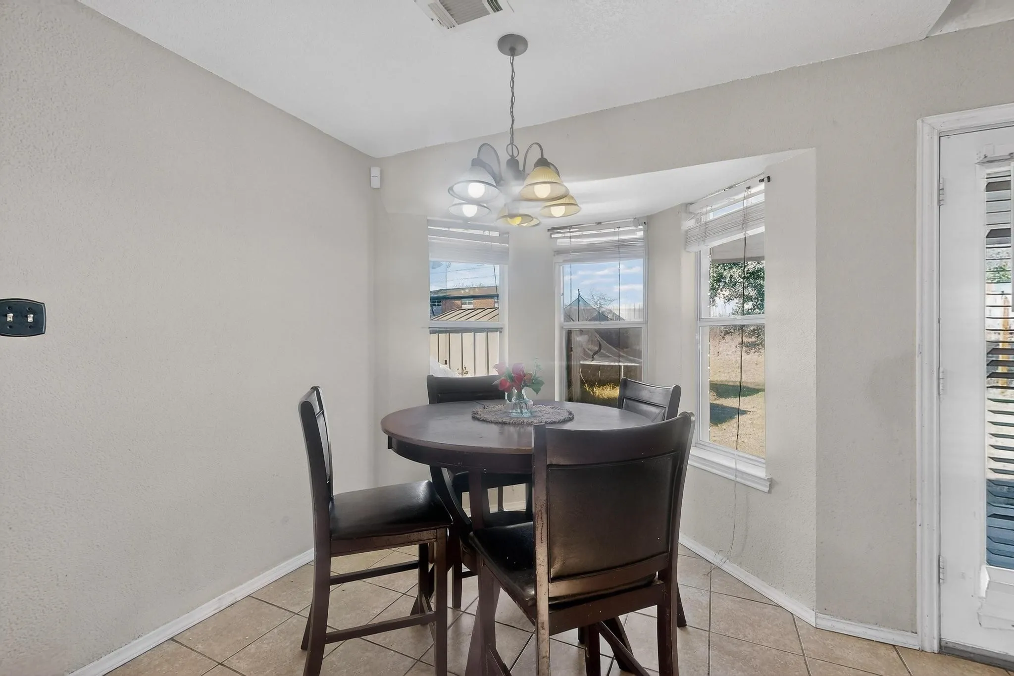 Bay window with multiple panes, ceramic tile flooring, and a multi-light pendant fixture