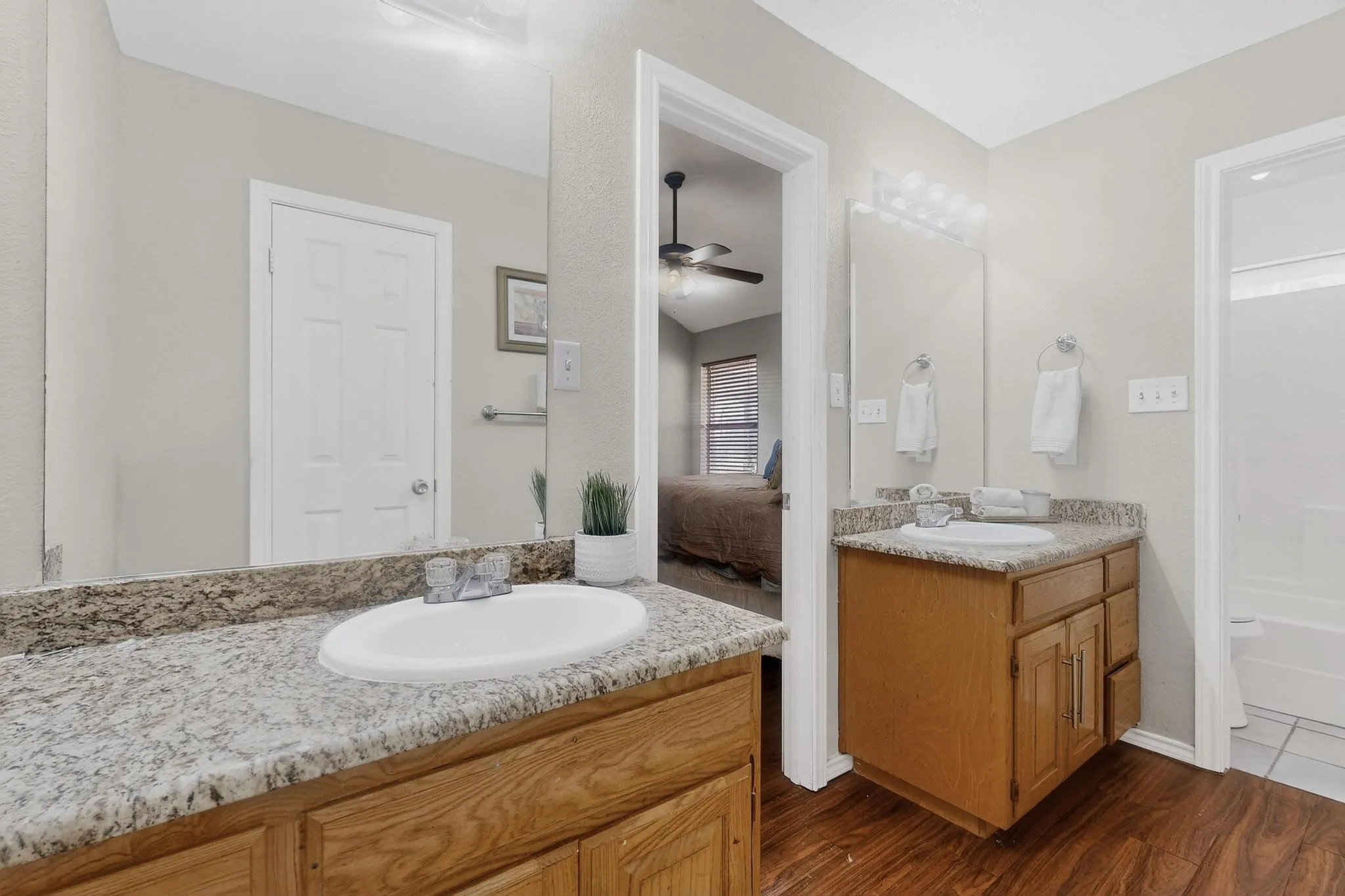Dual vanities with granite-style countertops, wood-finish cabinetry, and undermount sinks
