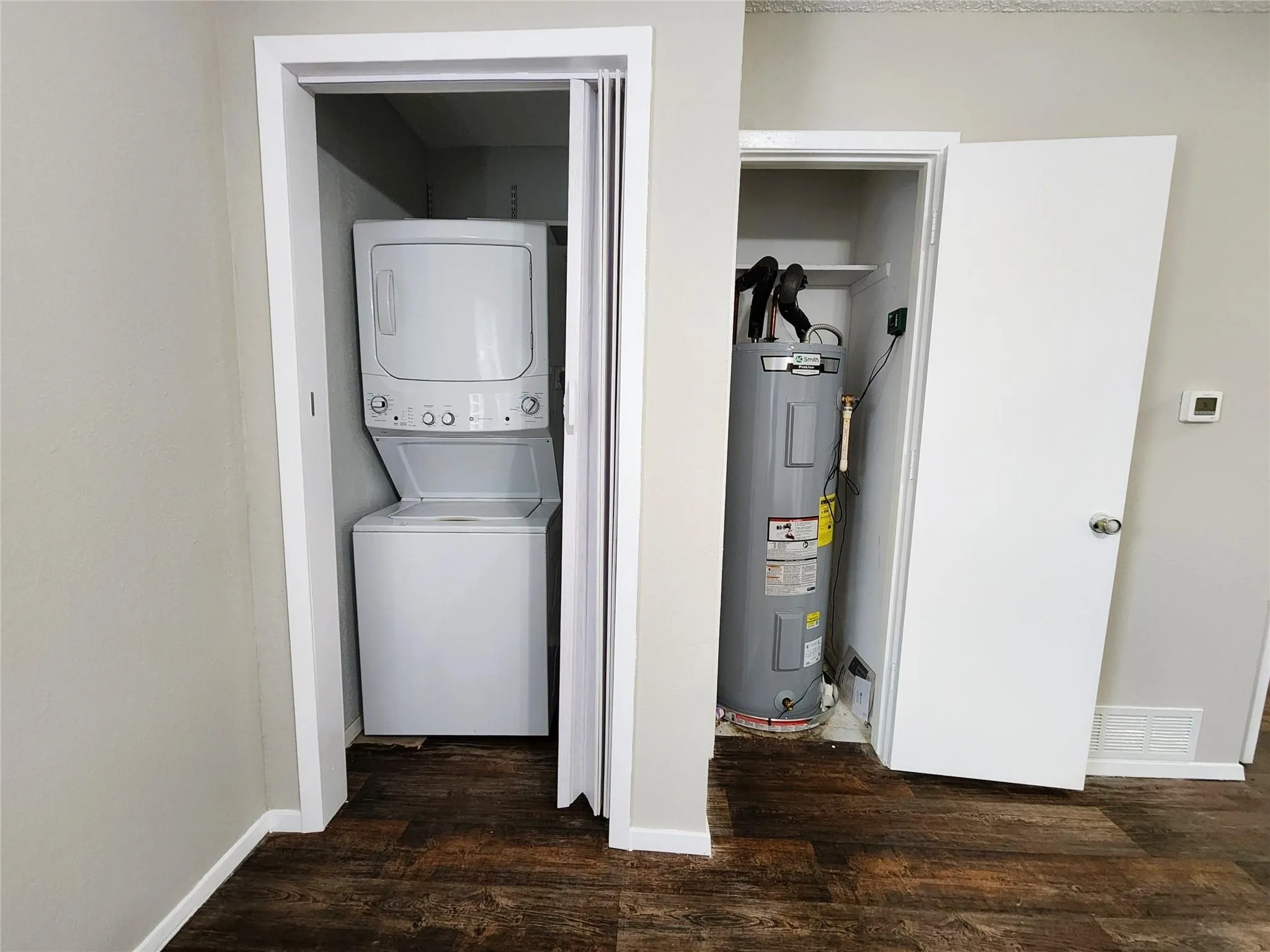 Stackable white laundry appliances with a bifold door