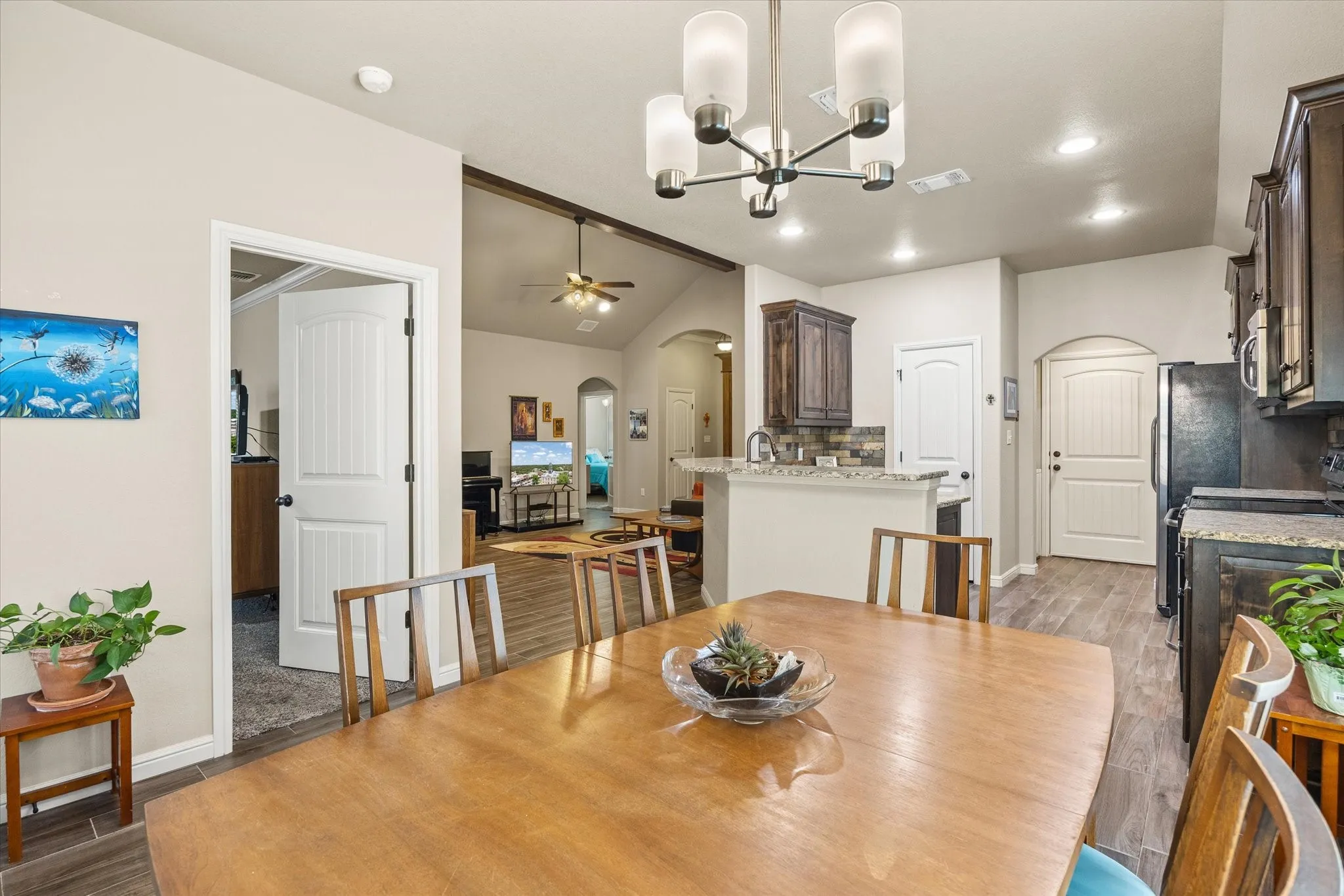 Dining area with contemporary chandelier, and wood -look tile flooring