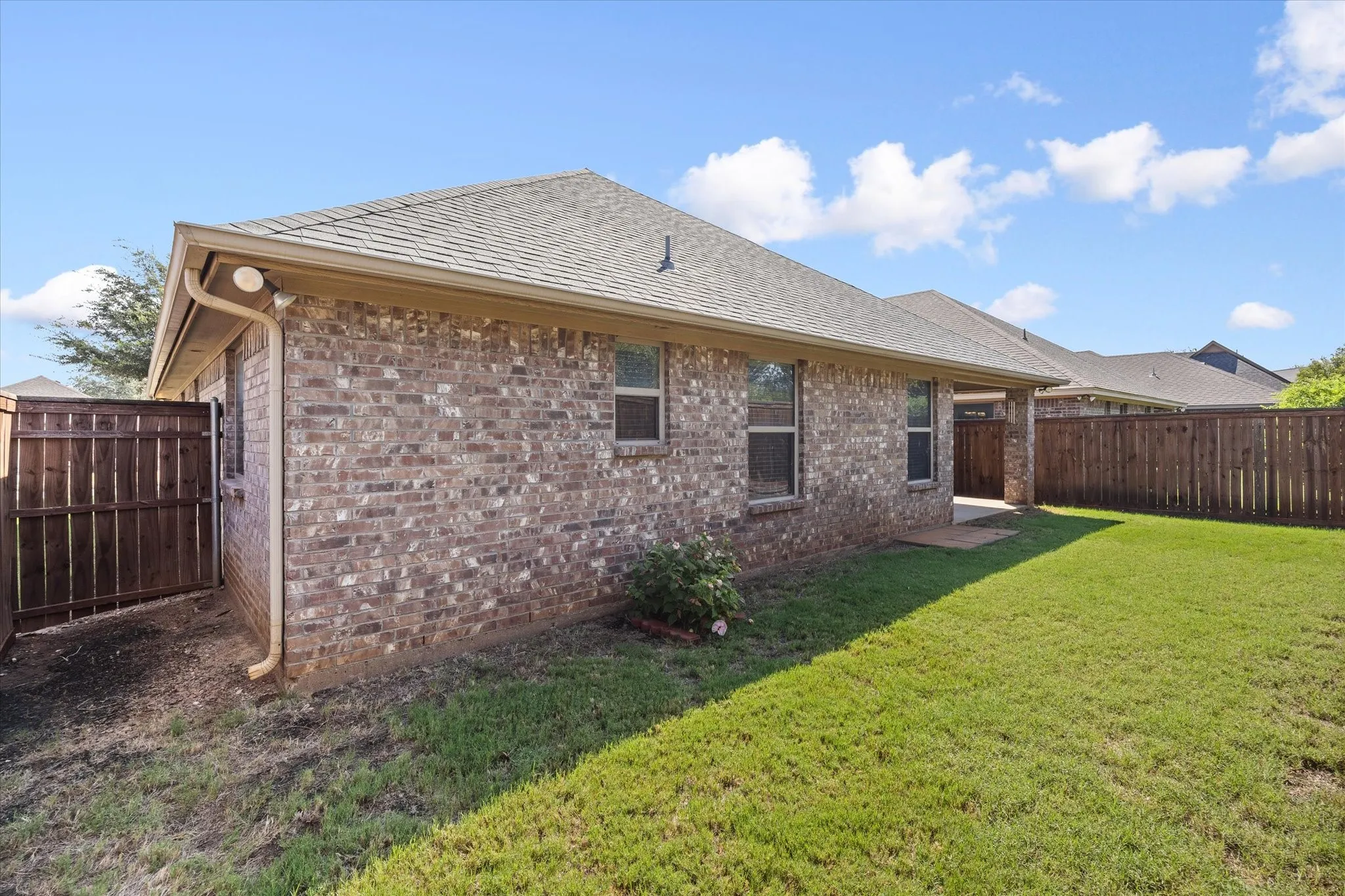 Full brick exterior with privacy fenced yard and whole house rain-gutters.