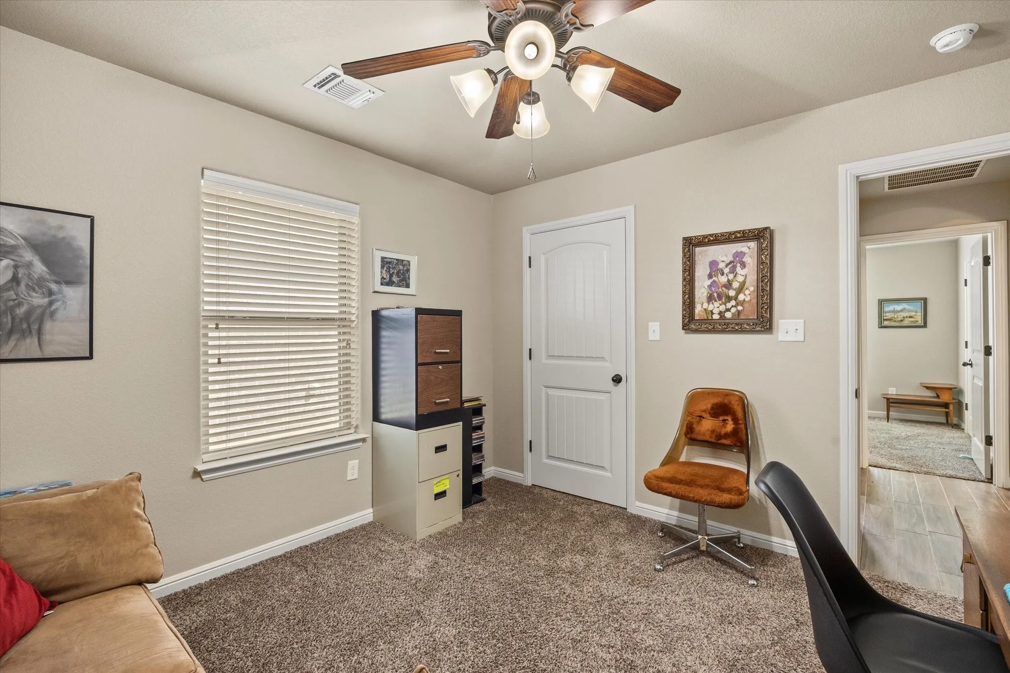 3rd bedroom with carpeted flooring with a ceiling fan light fixture and window with blinds - currently used as office or study