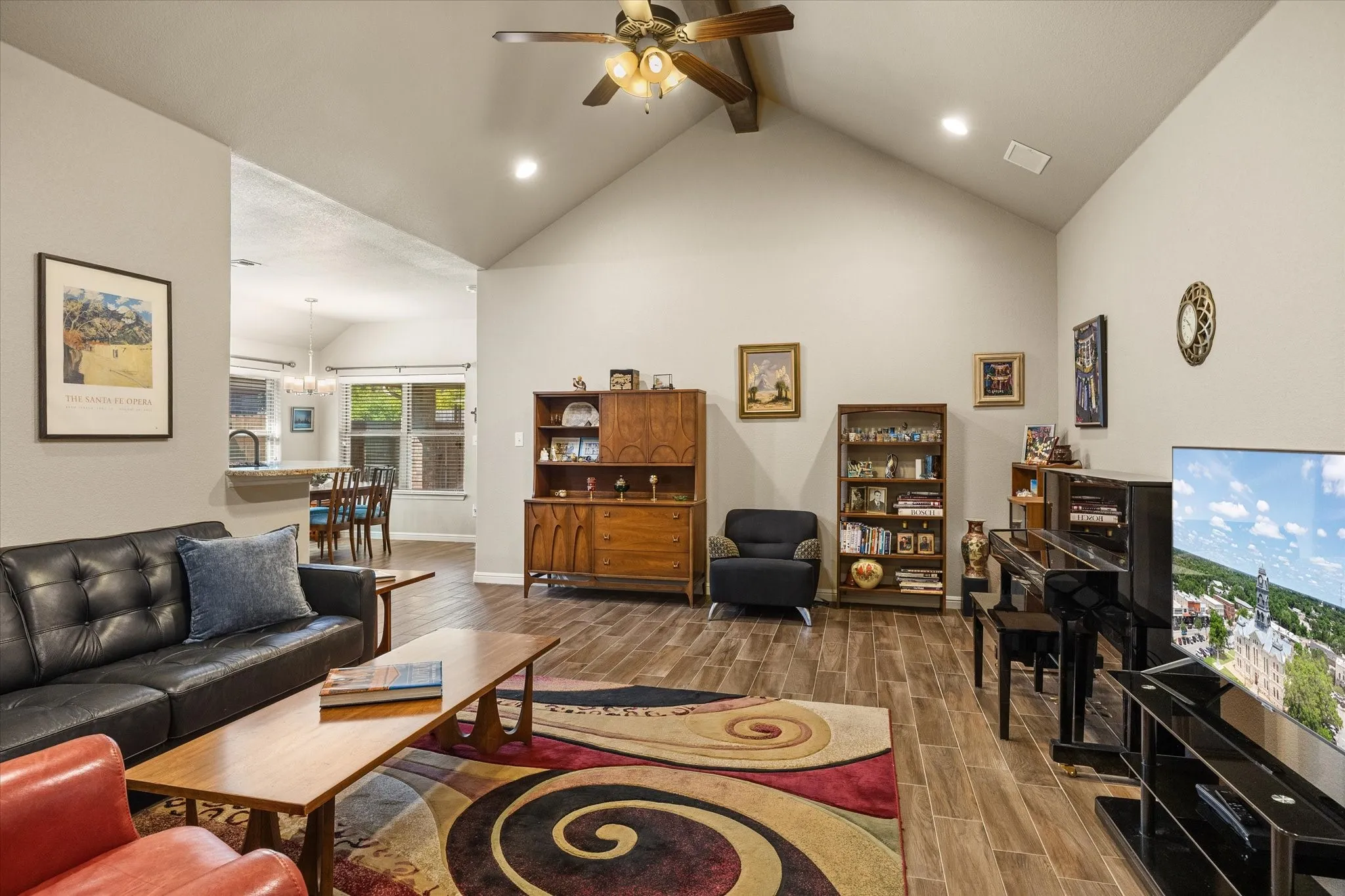 Vaulted ceiling with a ceiling fan, recessed lighting, wood-look tile flooring