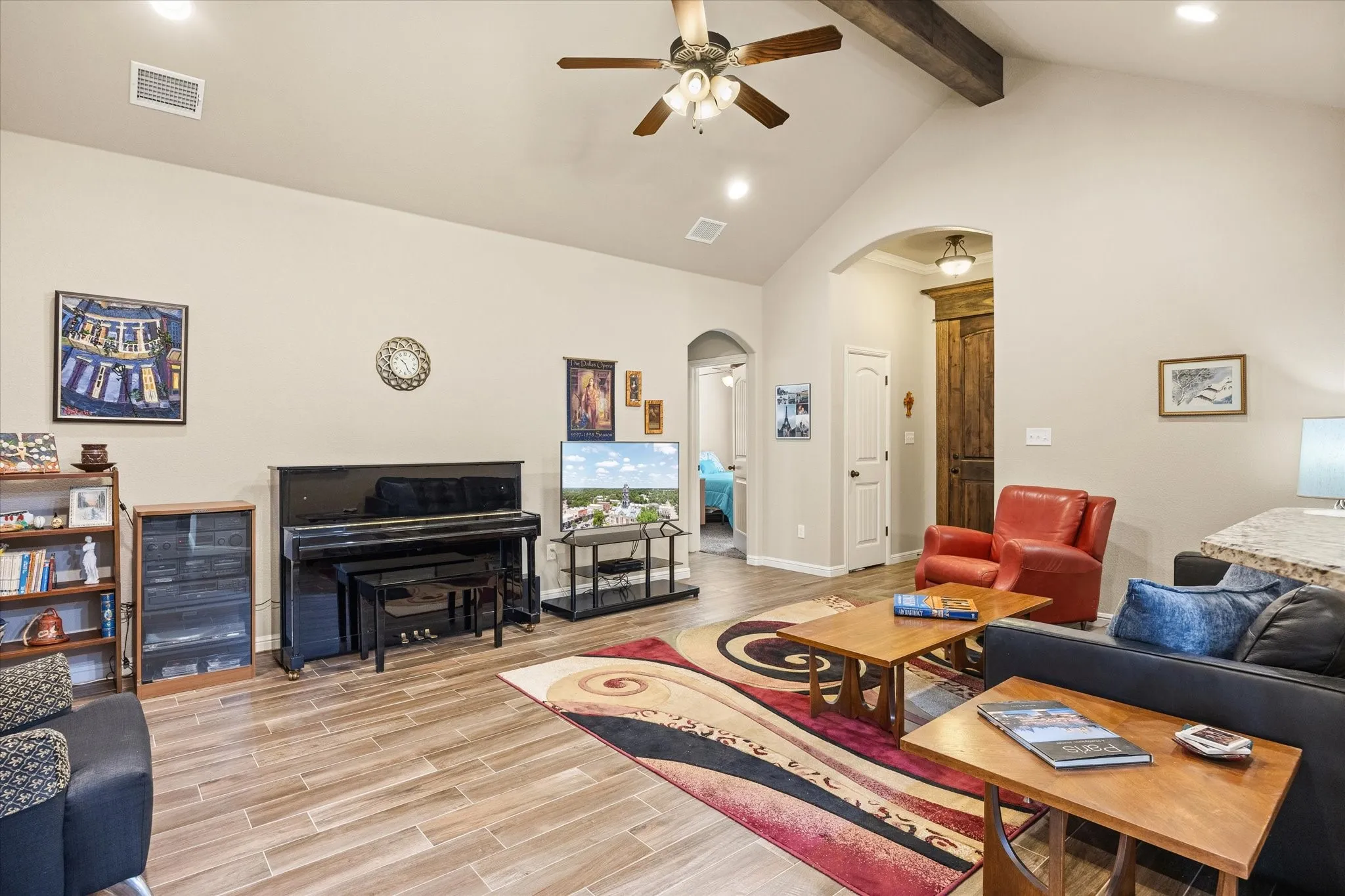 Vaulted ceiling with an exposed beam, wood-look tile flooring, recessed lighting, and a ceiling fan