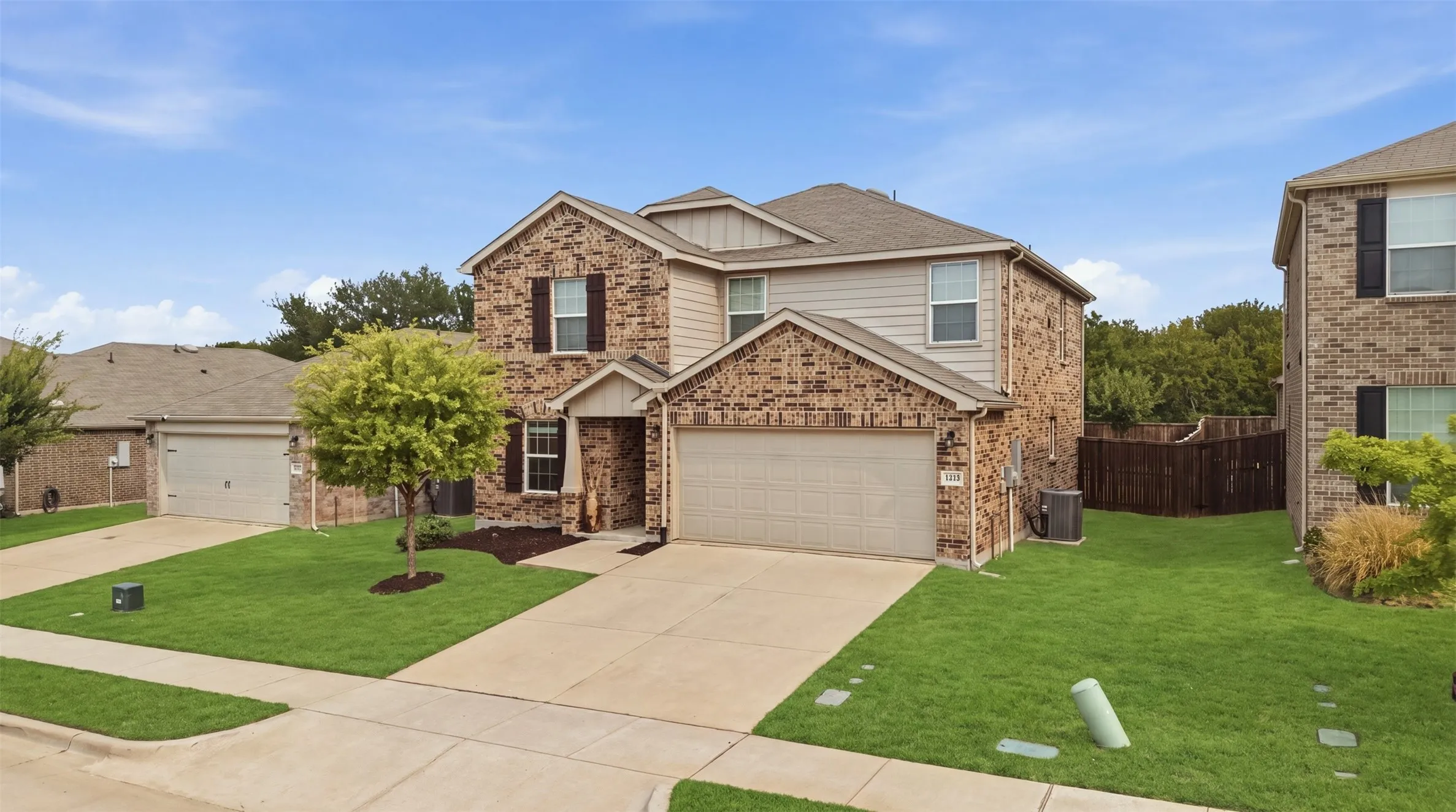 Two-story brick-and-siding exterior with an attached two-car garage and a welcoming concrete driveway

