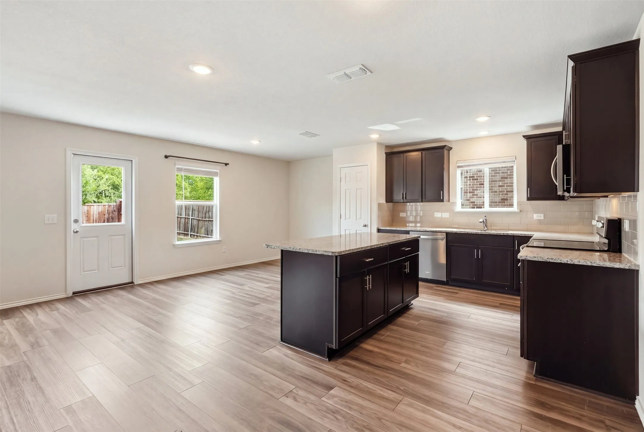 Inviting open-concept living space with warm wood-look flooring