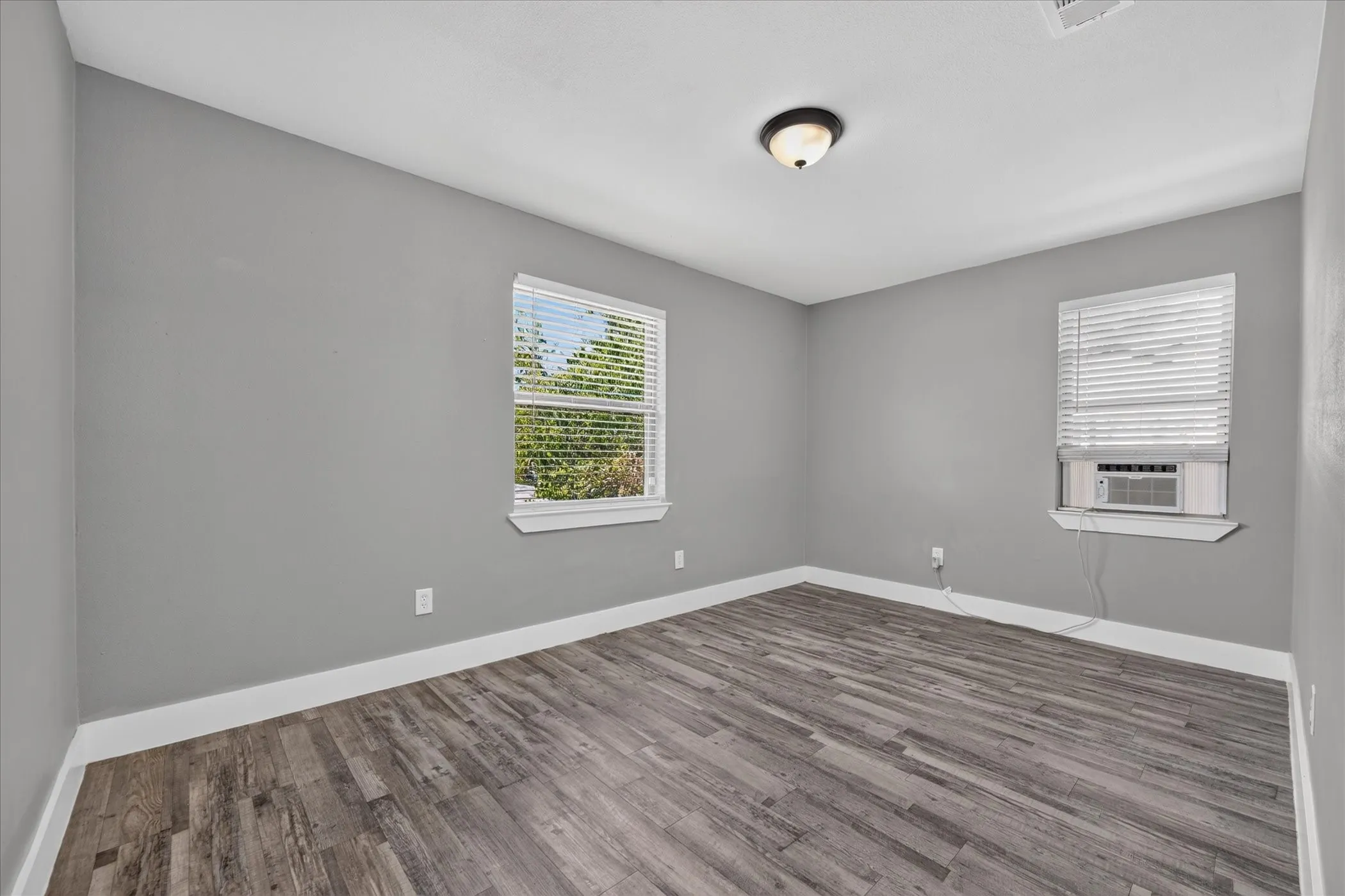 Recessed lighting, wood-finish flooring, and light gray wall paint