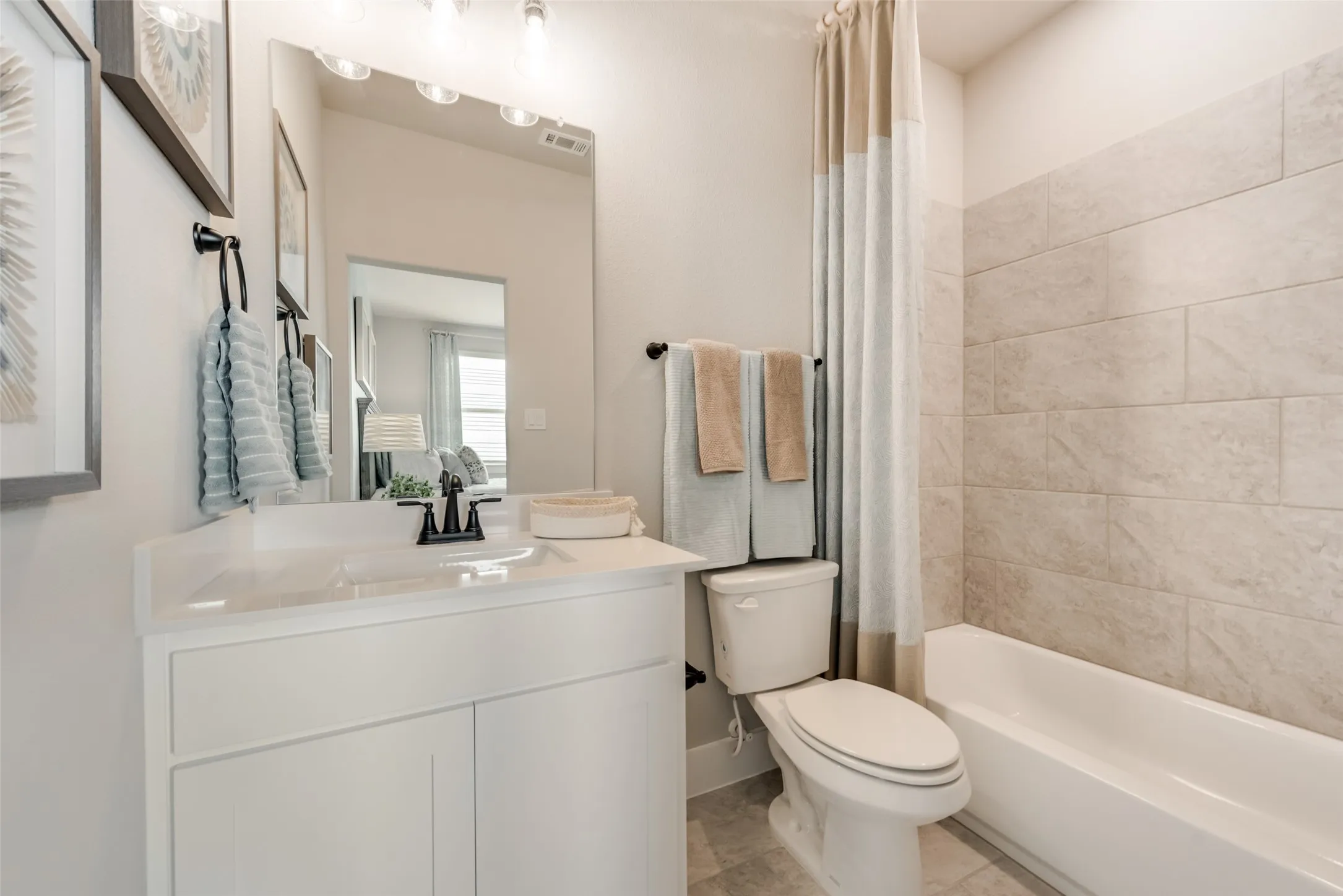 White vanity with integrated sink, black faucet, and rectangular mirror