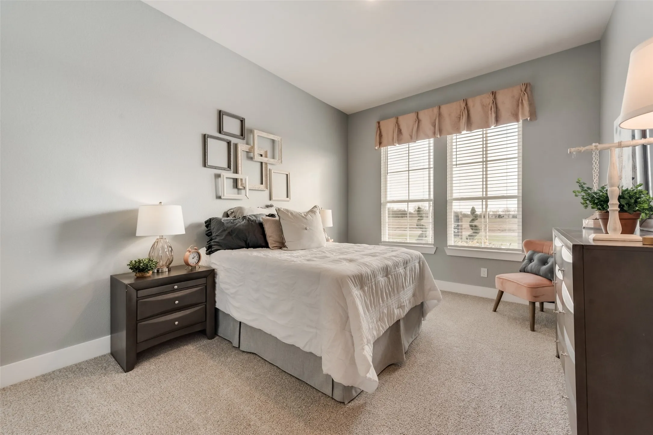Carpeted room with light gray walls and two large windows
