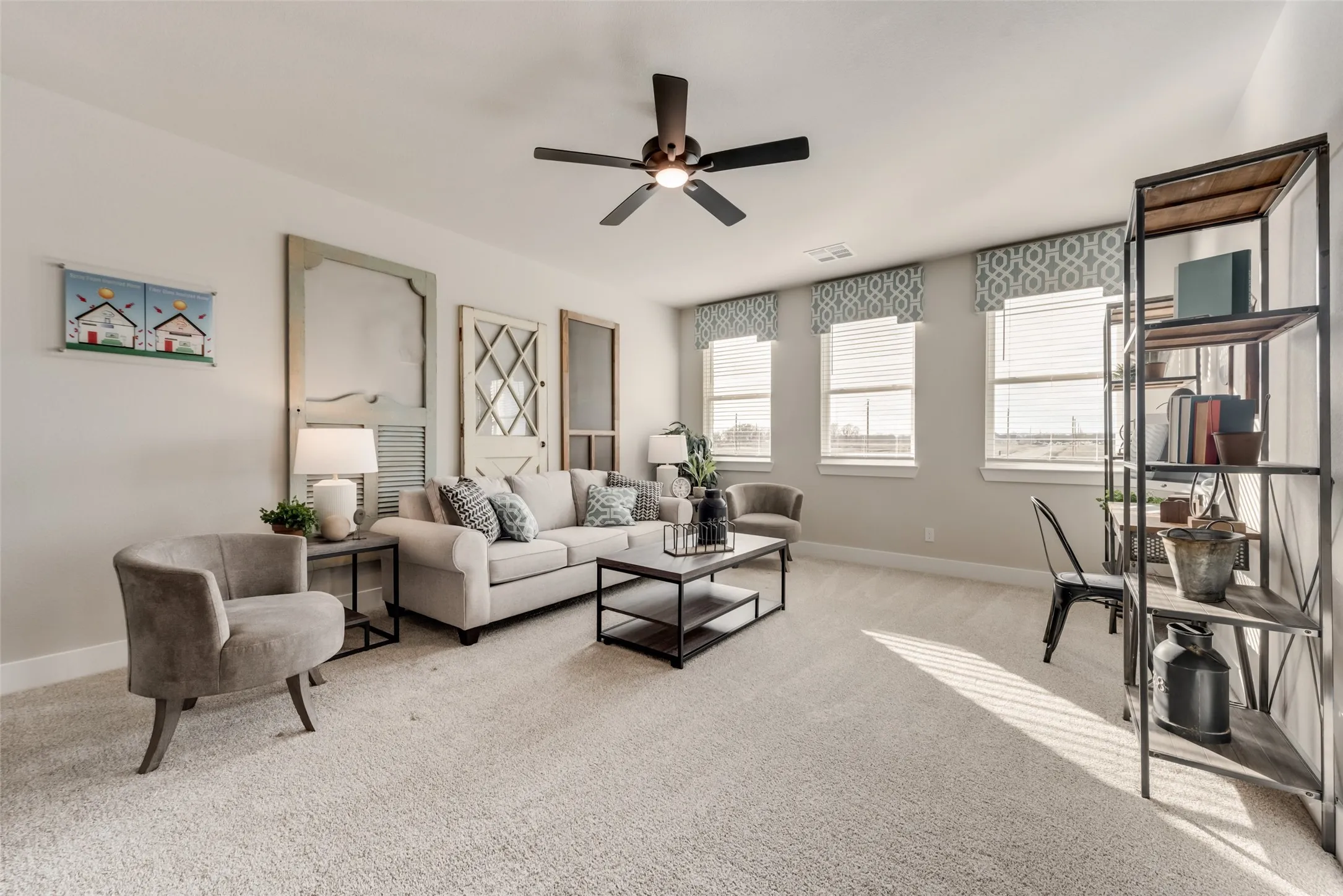 Spacious room featuring light-colored carpeting and multiple windows
