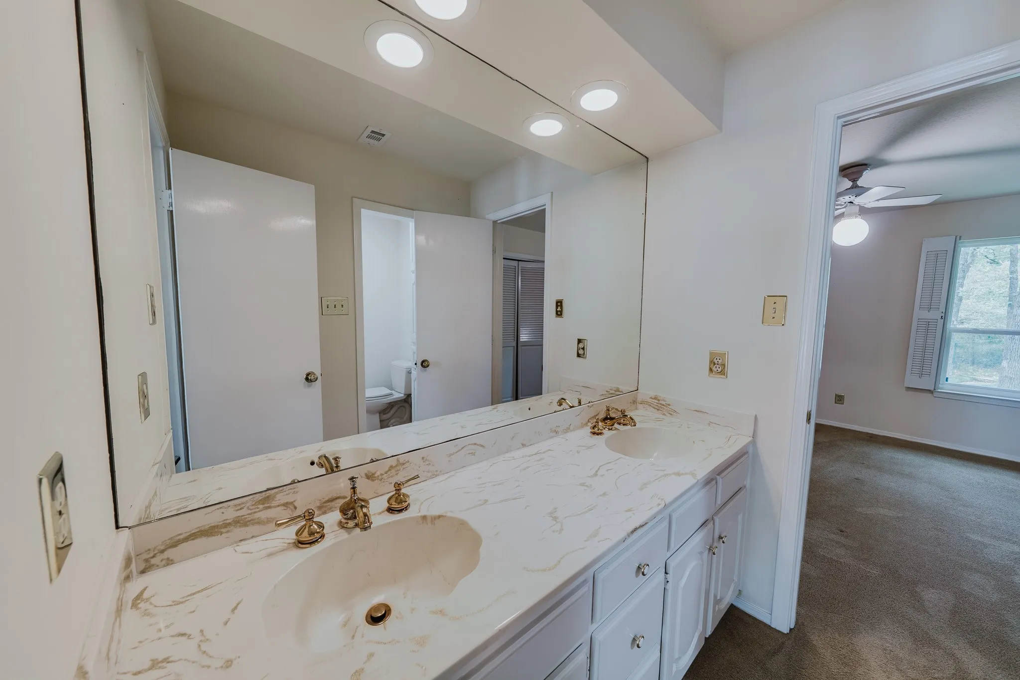 Dual vanity with undermount sinks, patterned countertop, and gold-tone fixtures