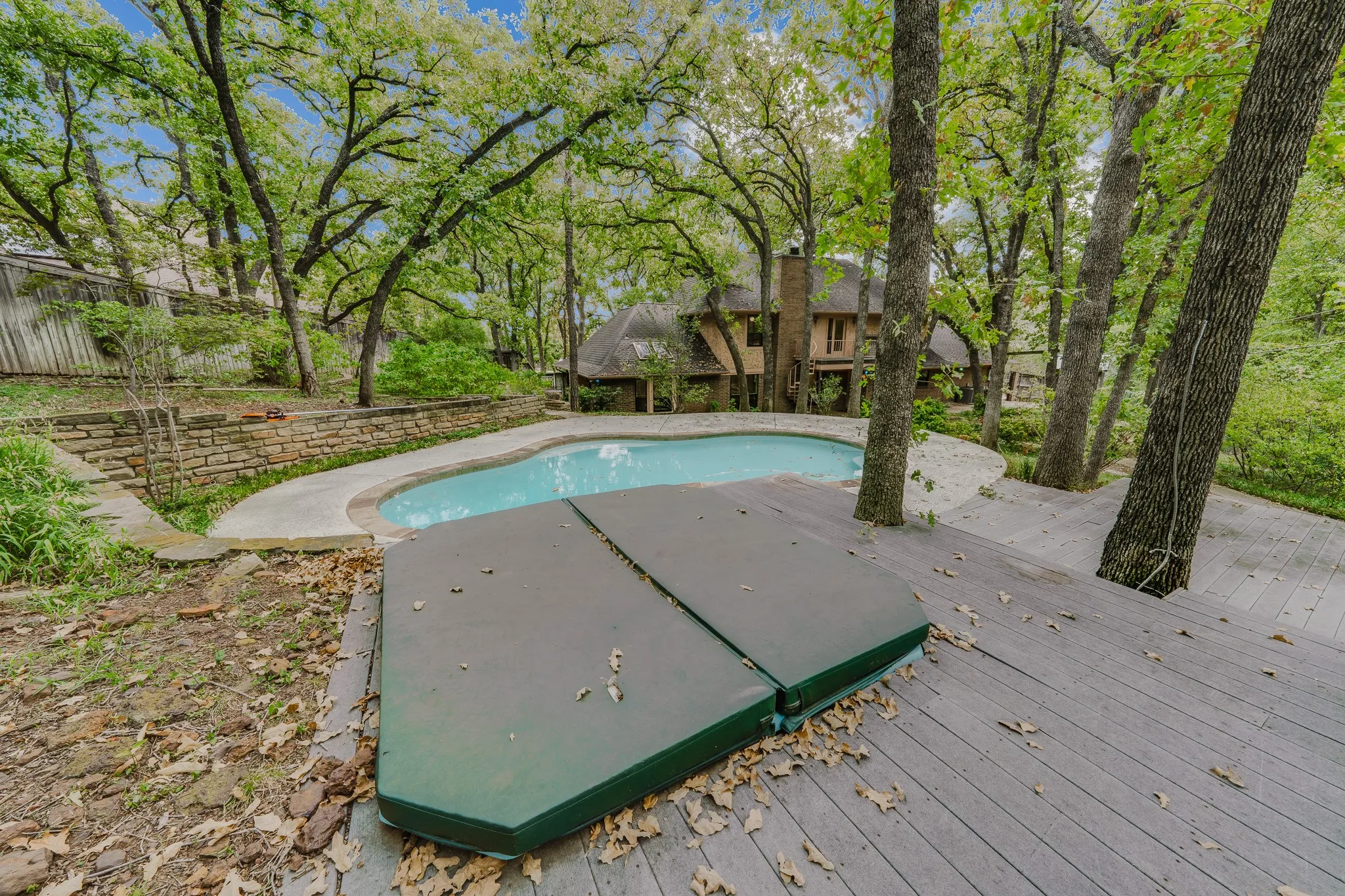 Curved swimming pool with surrounding concrete coping