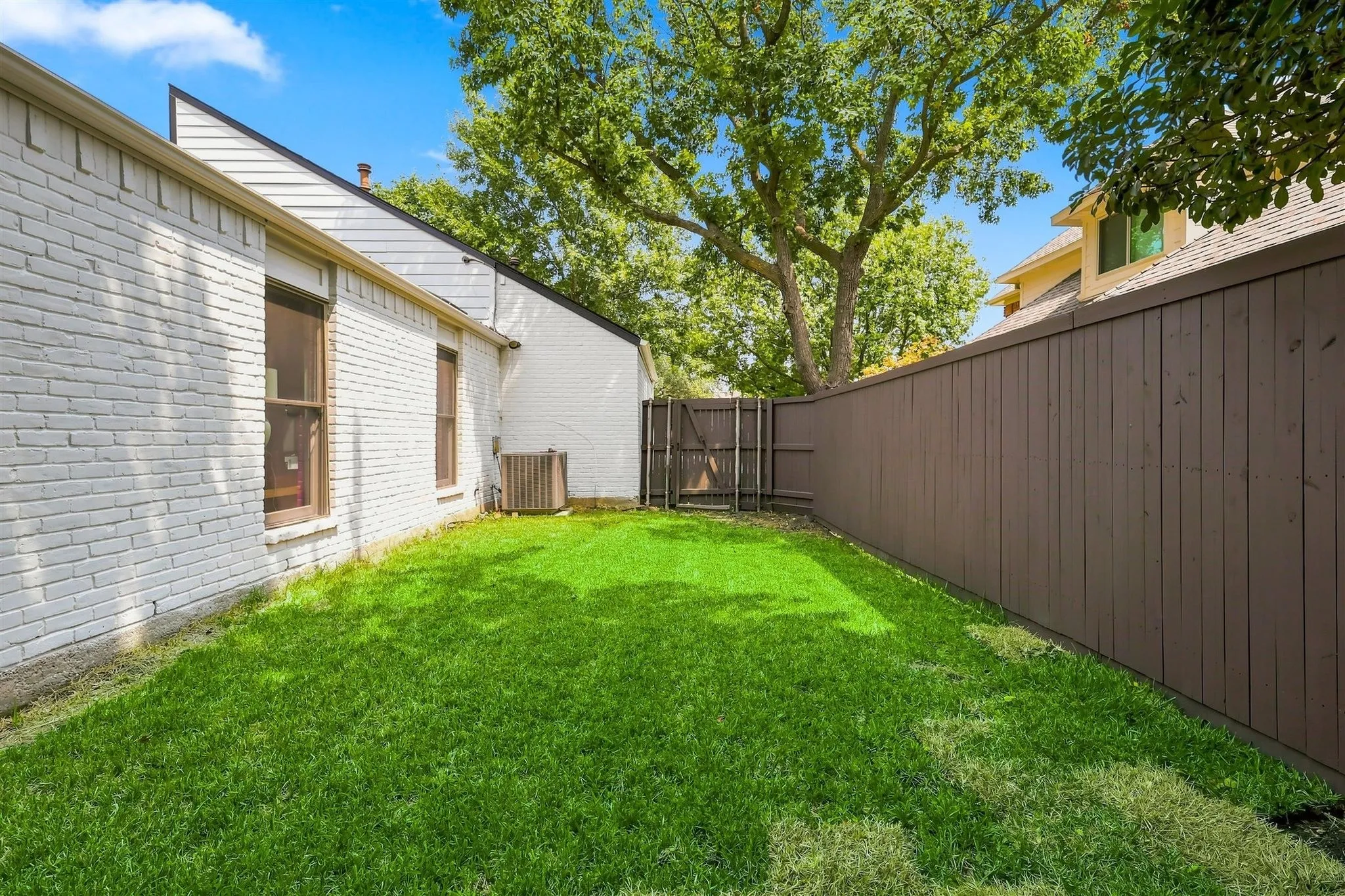 Private fenced yard featuring a well-maintained lawn