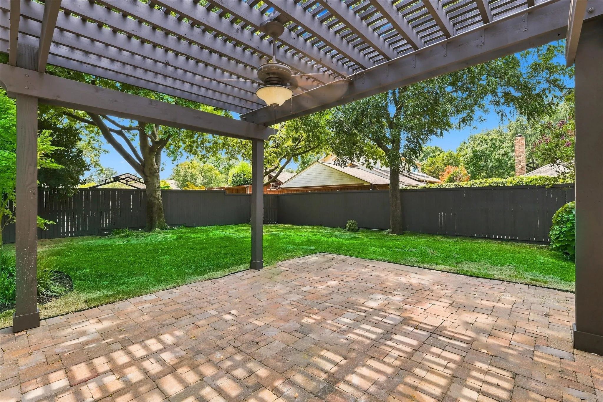 Expansive paver patio with a wood pergola