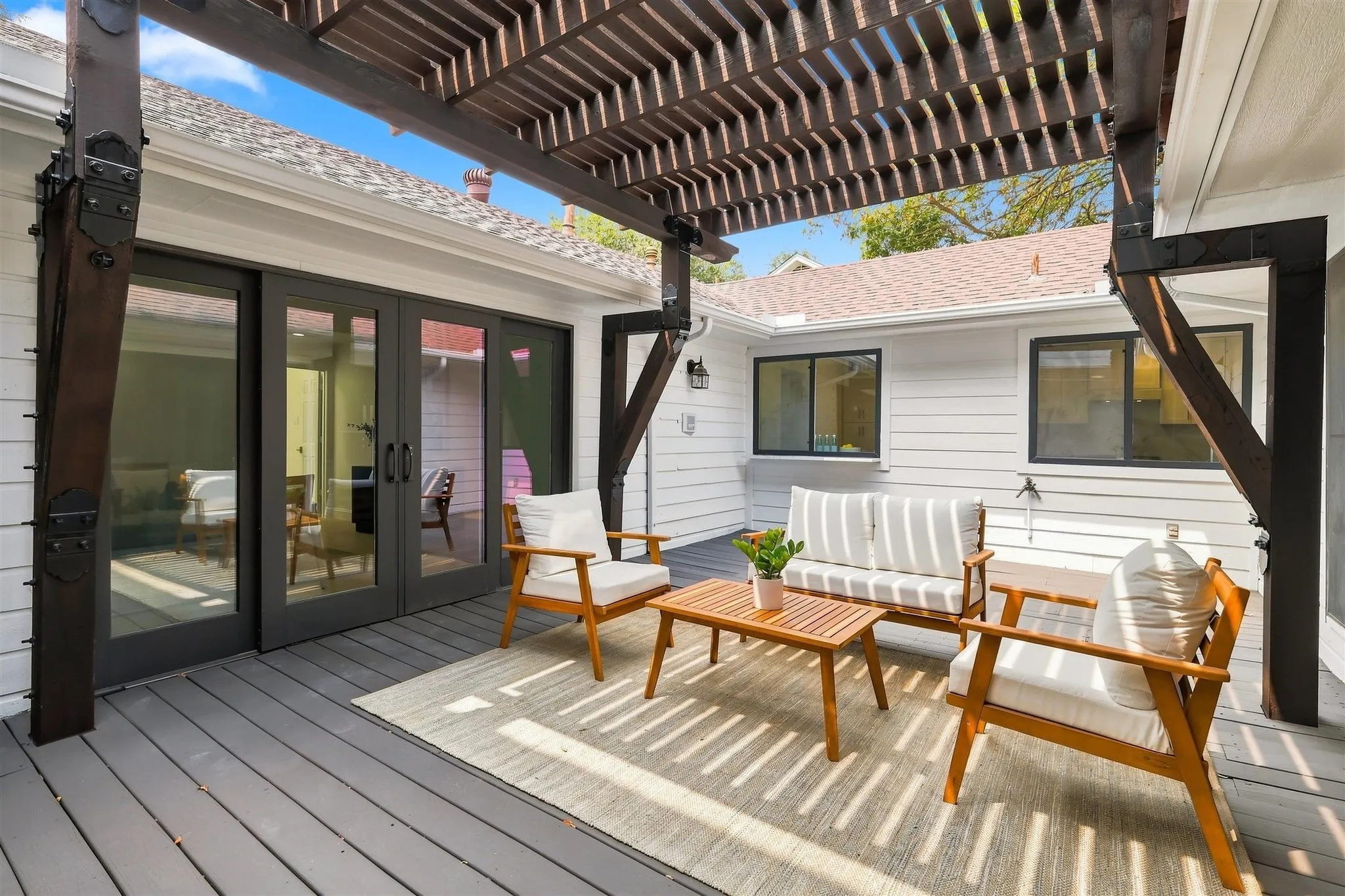 Expansive deck with a slatted pergola, offering an outdoor living area
