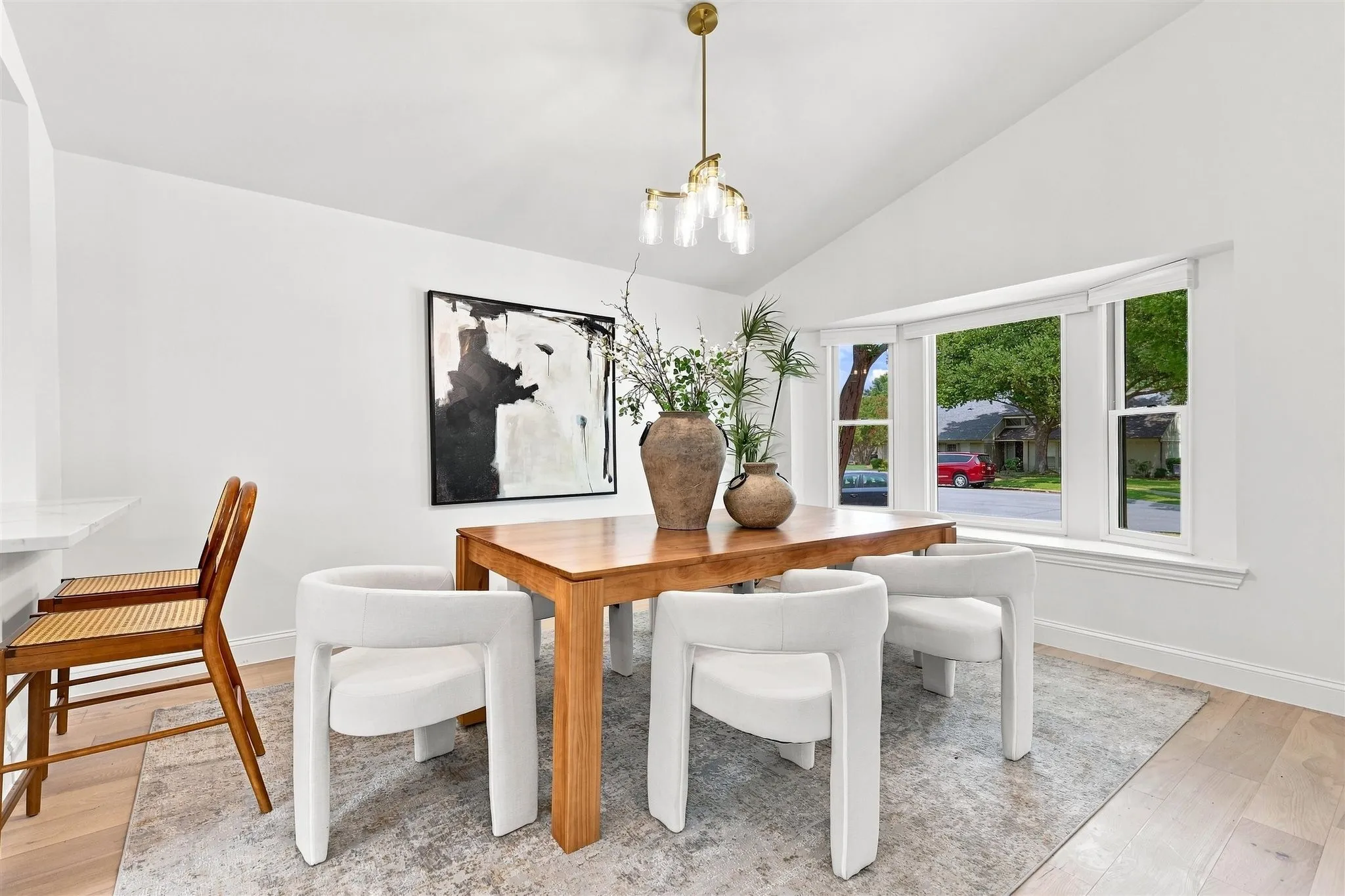 Vaulted ceilings, wood-finish flooring, and a multi-pane bay window