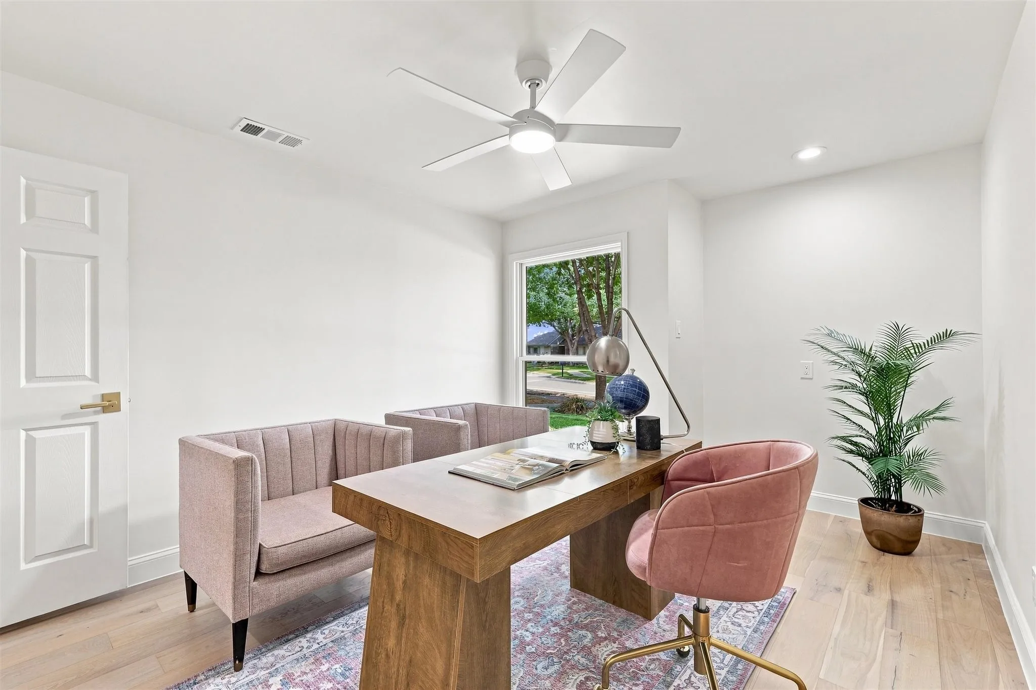 Hardwood-finish flooring, recessed lighting, ceiling fan with integrated light, and white paneled door