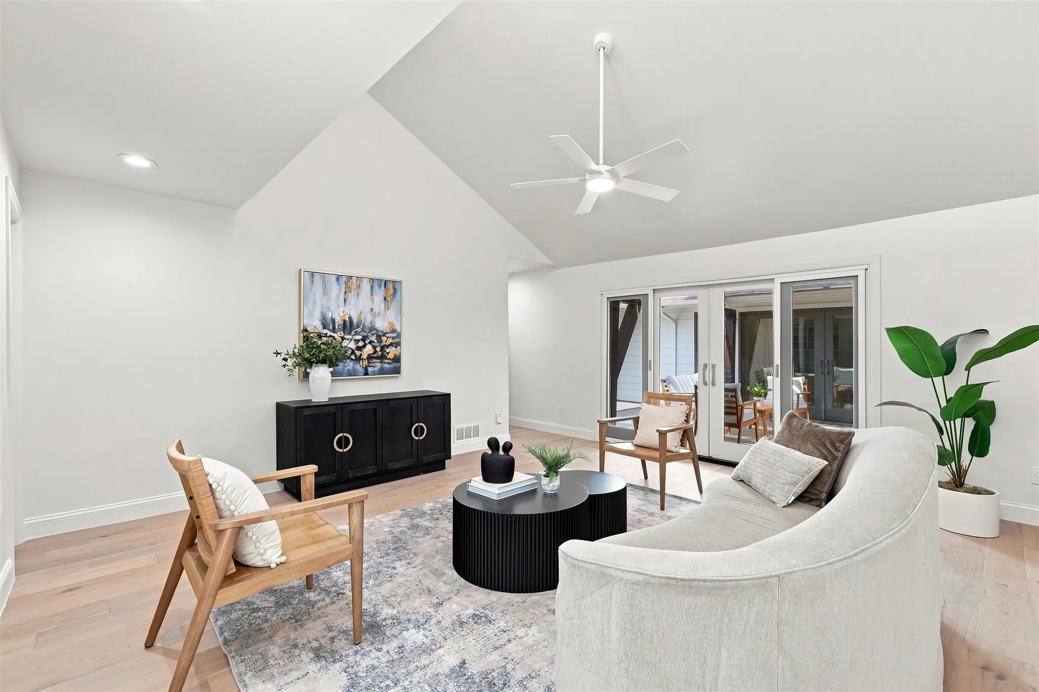 Vaulted ceiling with a ceiling fan, light wood-finish flooring, recessed lighting, and sliding glass doors