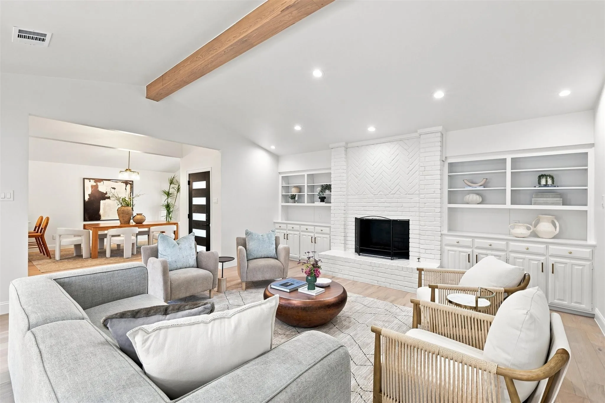 Vaulted ceilings with an exposed wood beam, recessed lighting, and wood-finish flooring