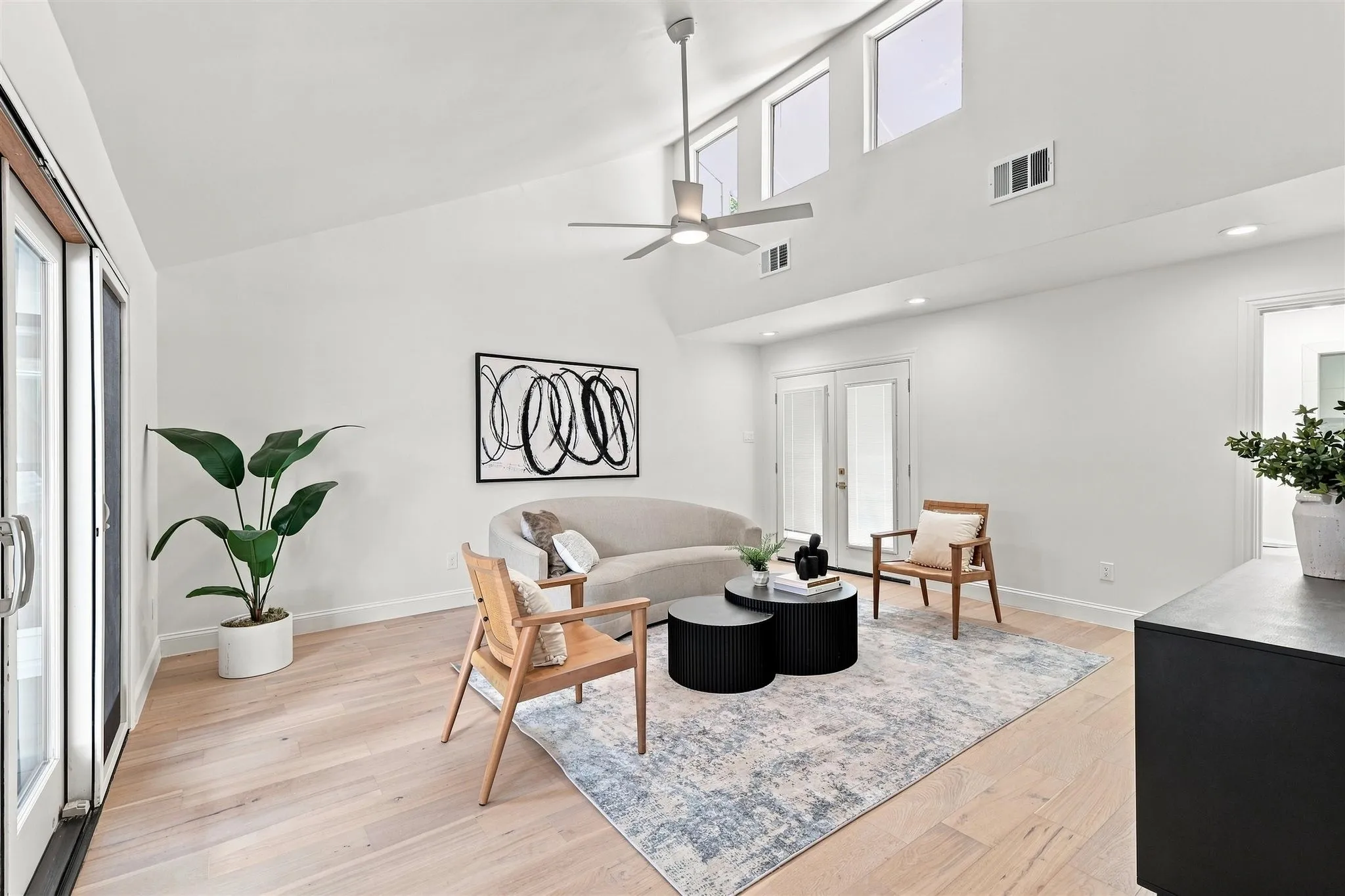 Vaulted ceiling with transom windows, wood-finish flooring, recessed lighting, and a ceiling fan