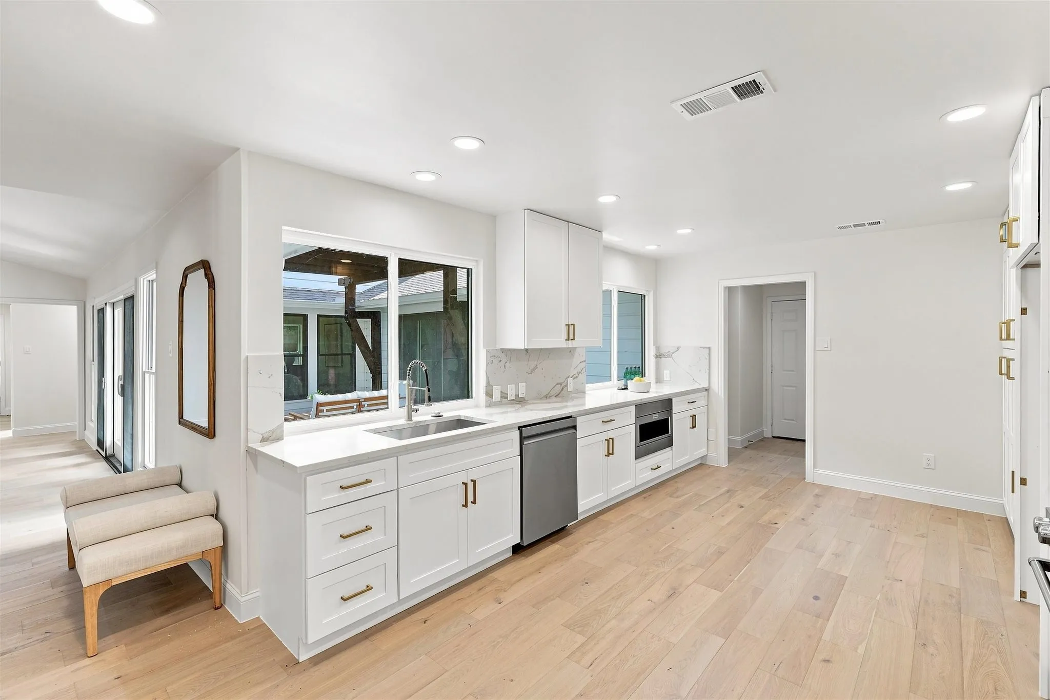 Kitchen featuring white cabinetry, light wood-finish flooring, recessed lighting, and a white countertop with a matching backsplash