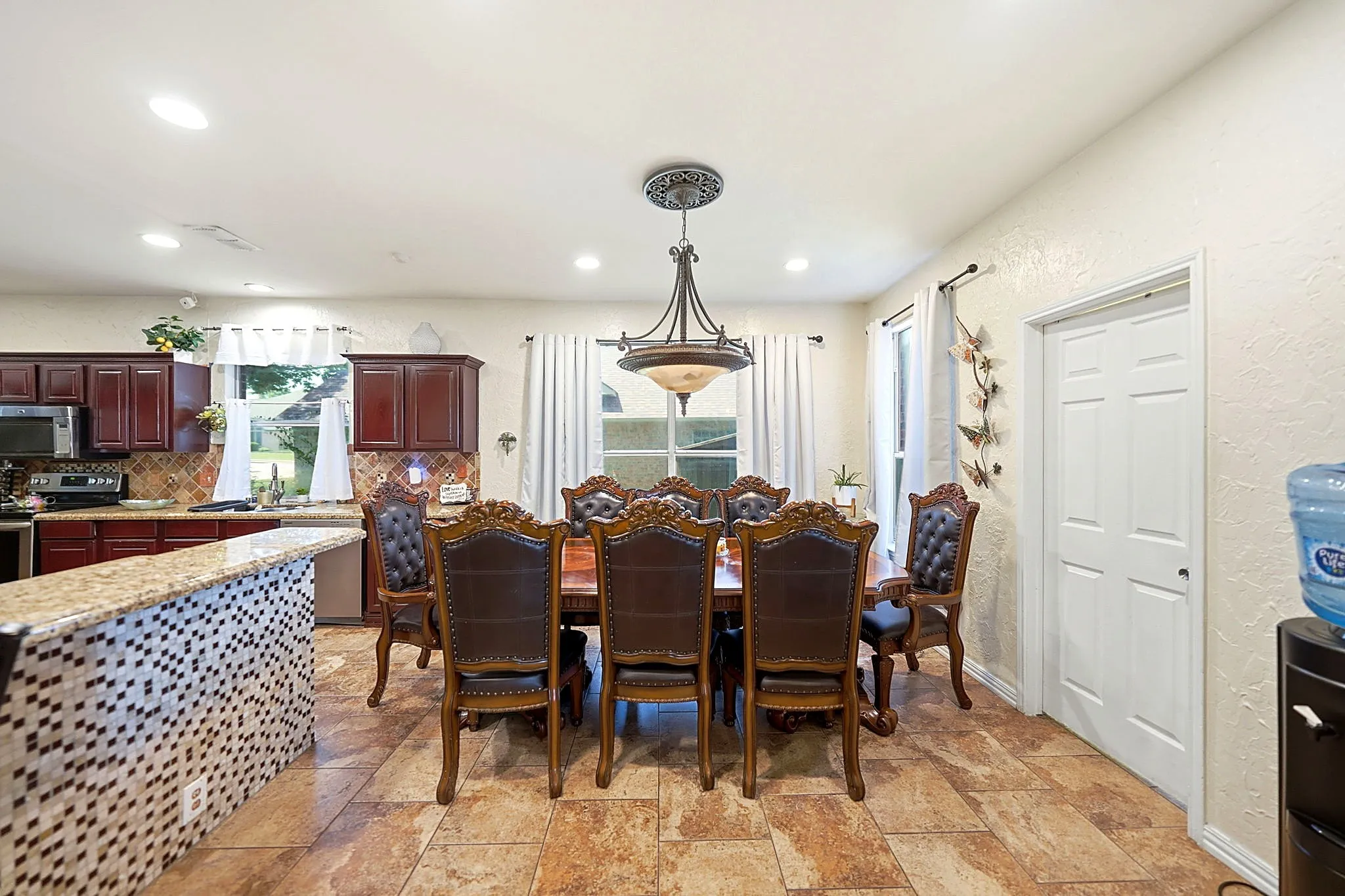 Kitchen with dark wood cabinetry, stainless steel appliances, and a tiled backsplash