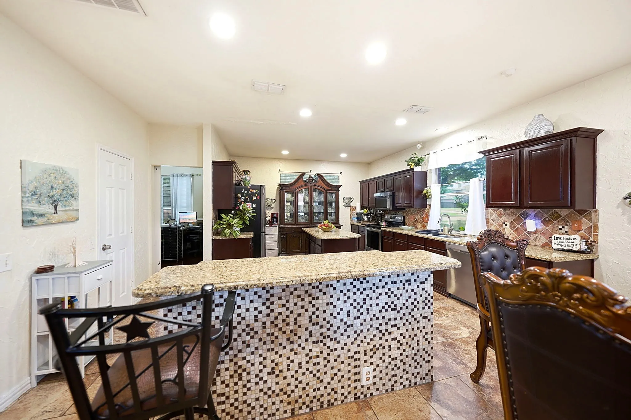Kitchen featuring dark wood-finish cabinetry, a mosaic tile backsplash, stainless steel appliances, and recessed lighting