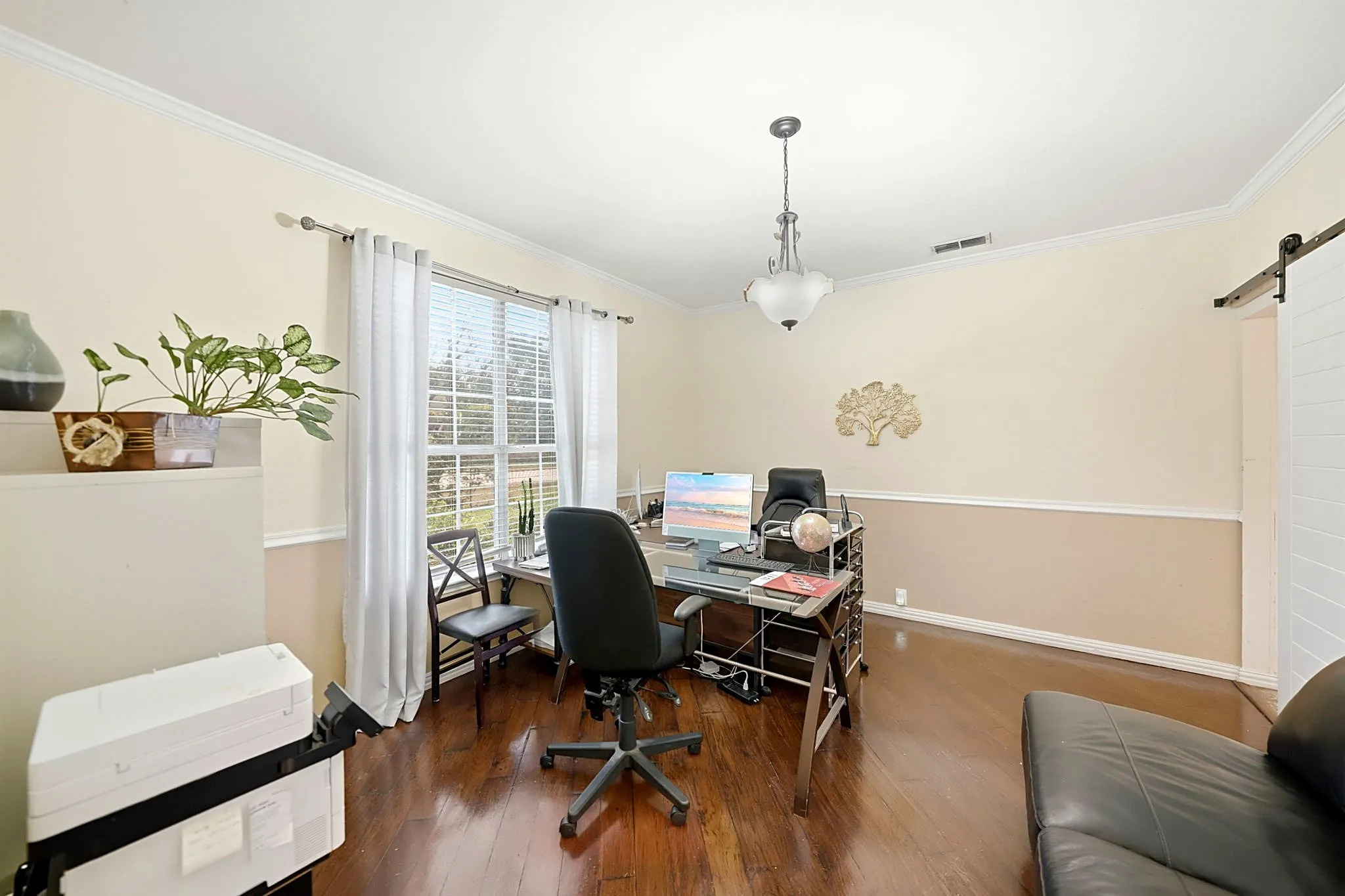 Wood-finish flooring, crown molding, chair rail molding, and a barn door entry