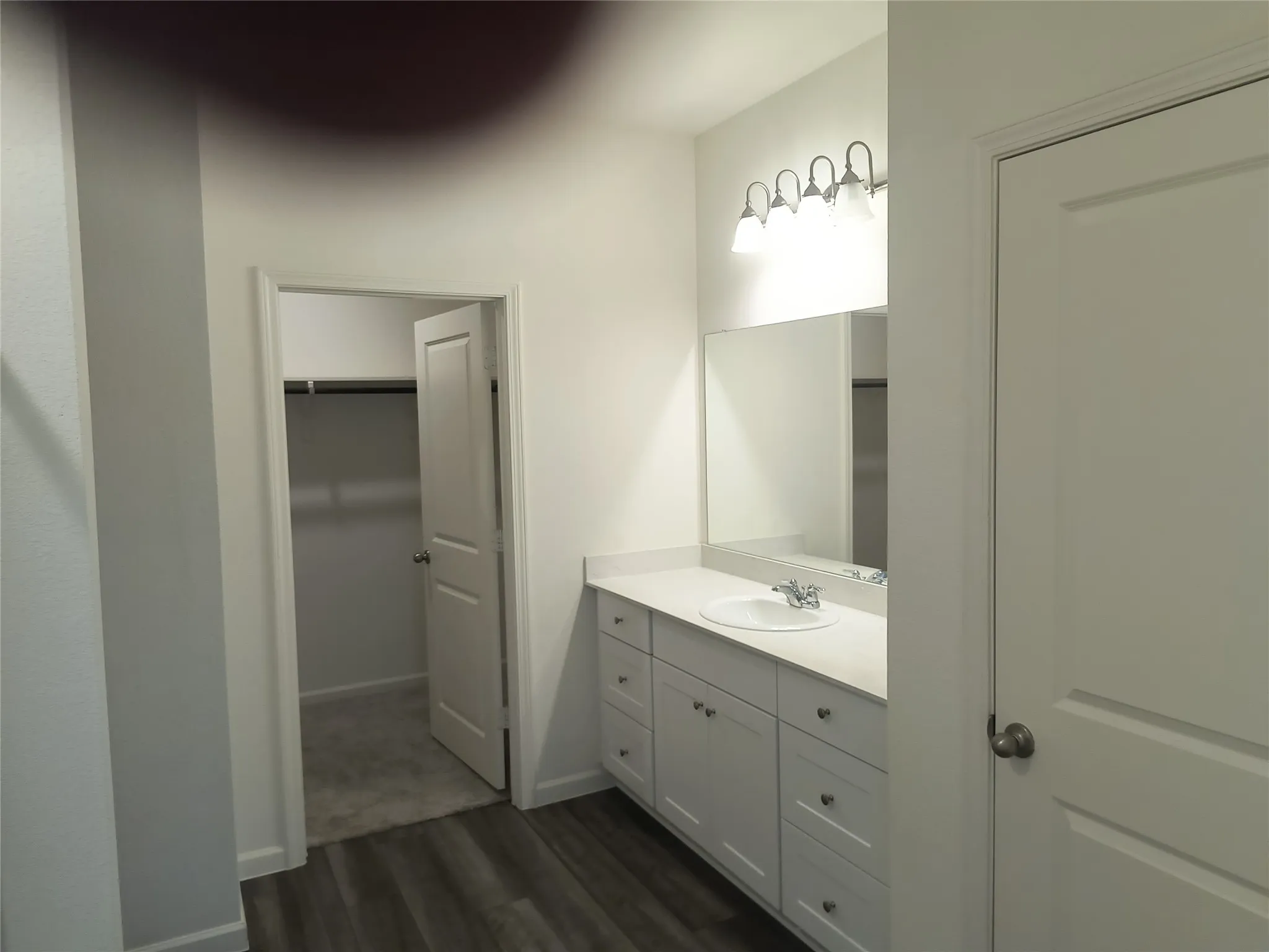 Spacious vanity with white cabinetry, integrated sink, and generous countertop