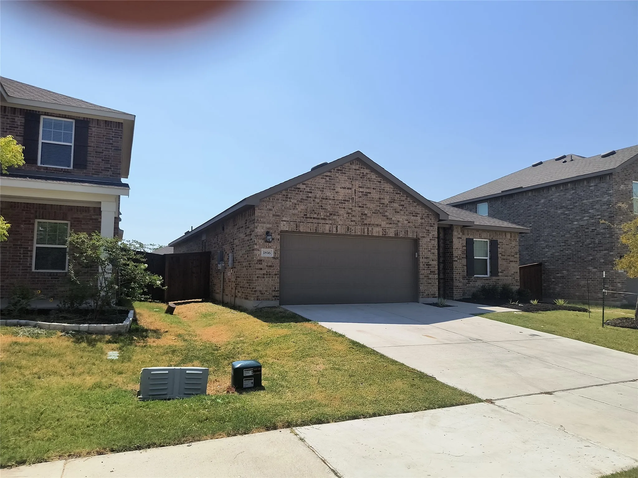 Brick facade with a gabled roof, attached two-car garage, and a concrete driveway